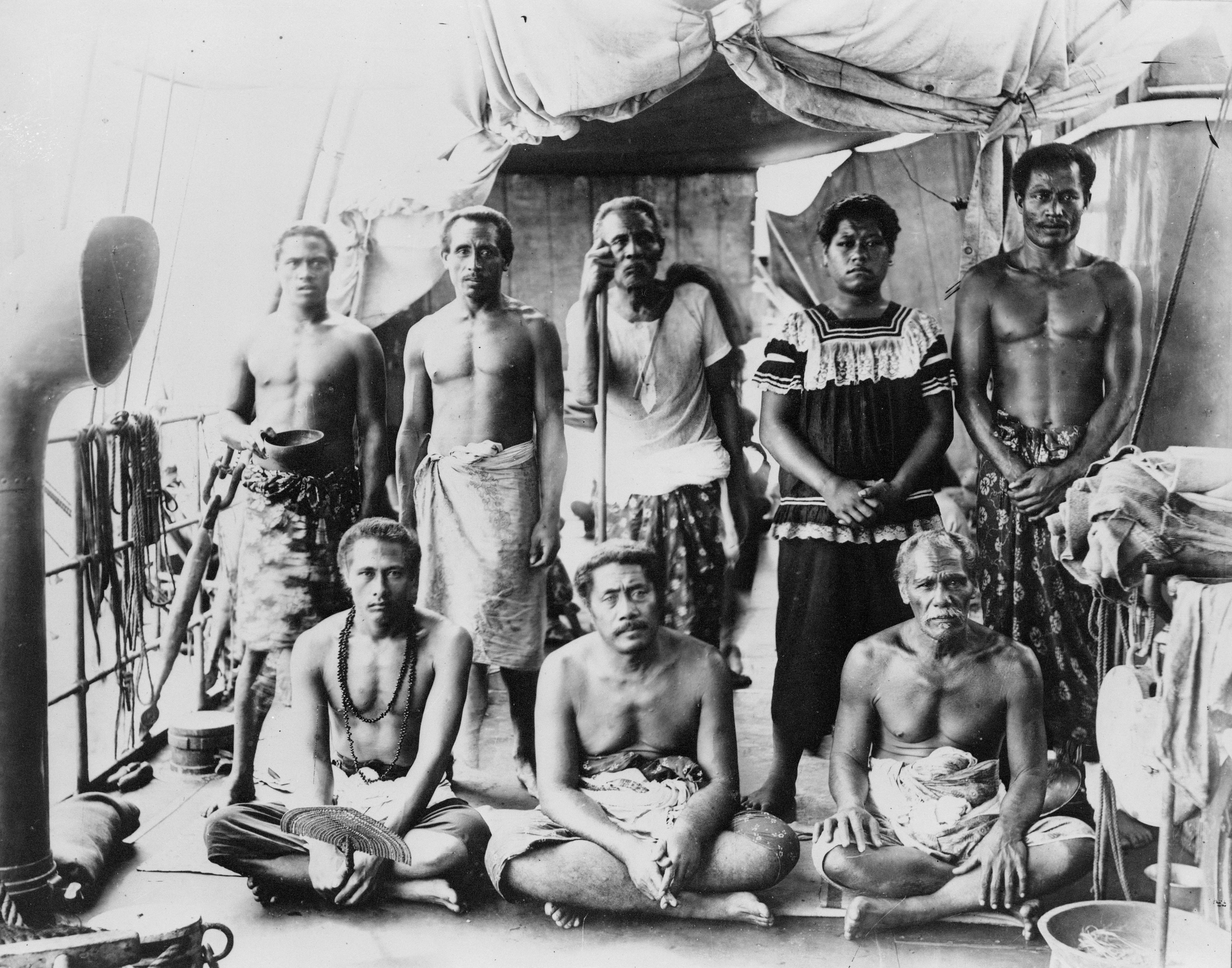 Pemidato yang dibuang negeri Lauaki Namulauʻulu Mamoe (berdiri ketiga dari kiri dengan tongkat pemidato) dan ketua-ketua lain di atas kapal perang Jerman yang membawa mereka ke pembuangan di Saipan, 1909.