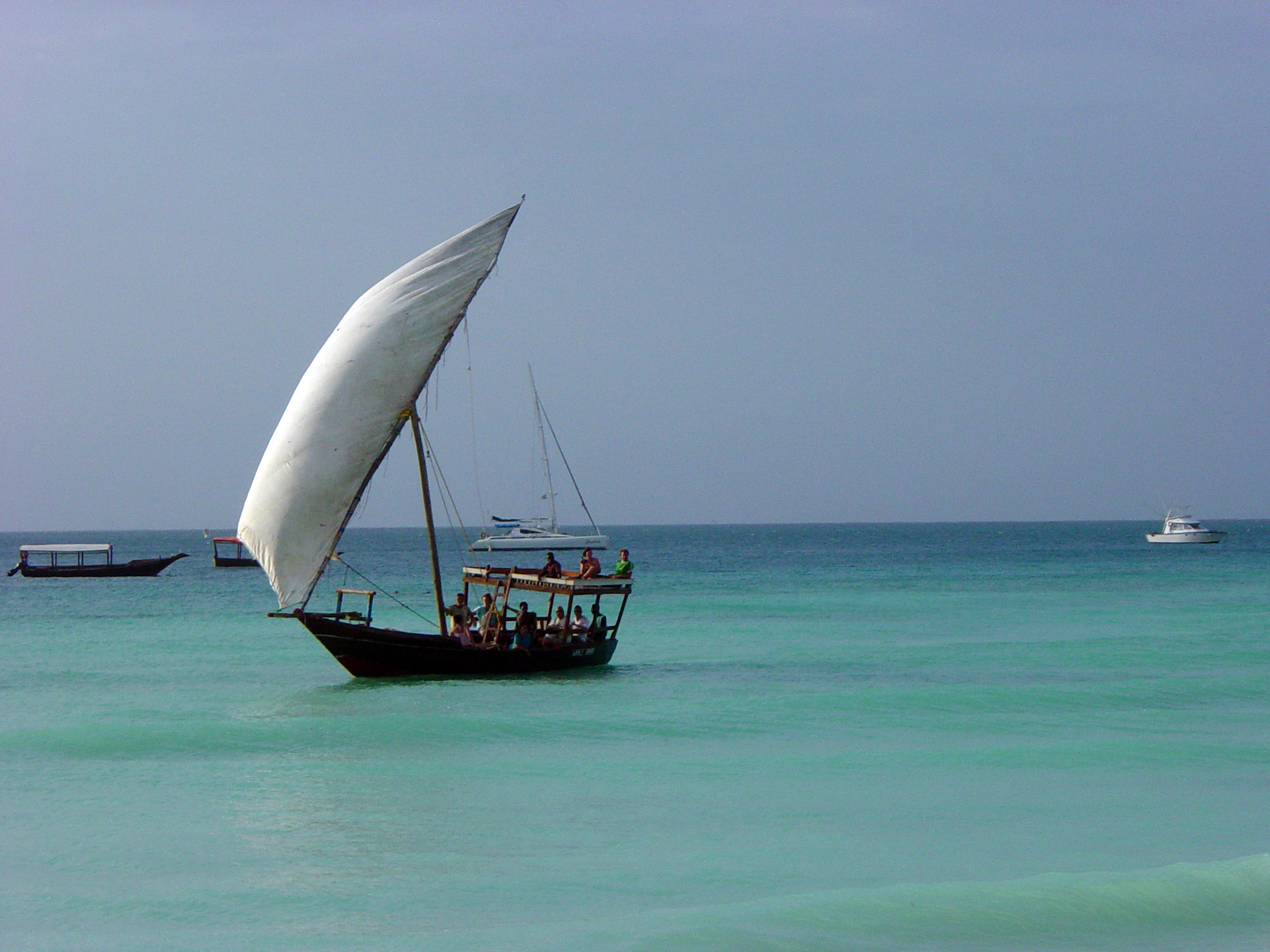 A large dhow with lateen sail rigs, a common vessel in the historical maritime trade of the Indian Ocean, including the Comoros.