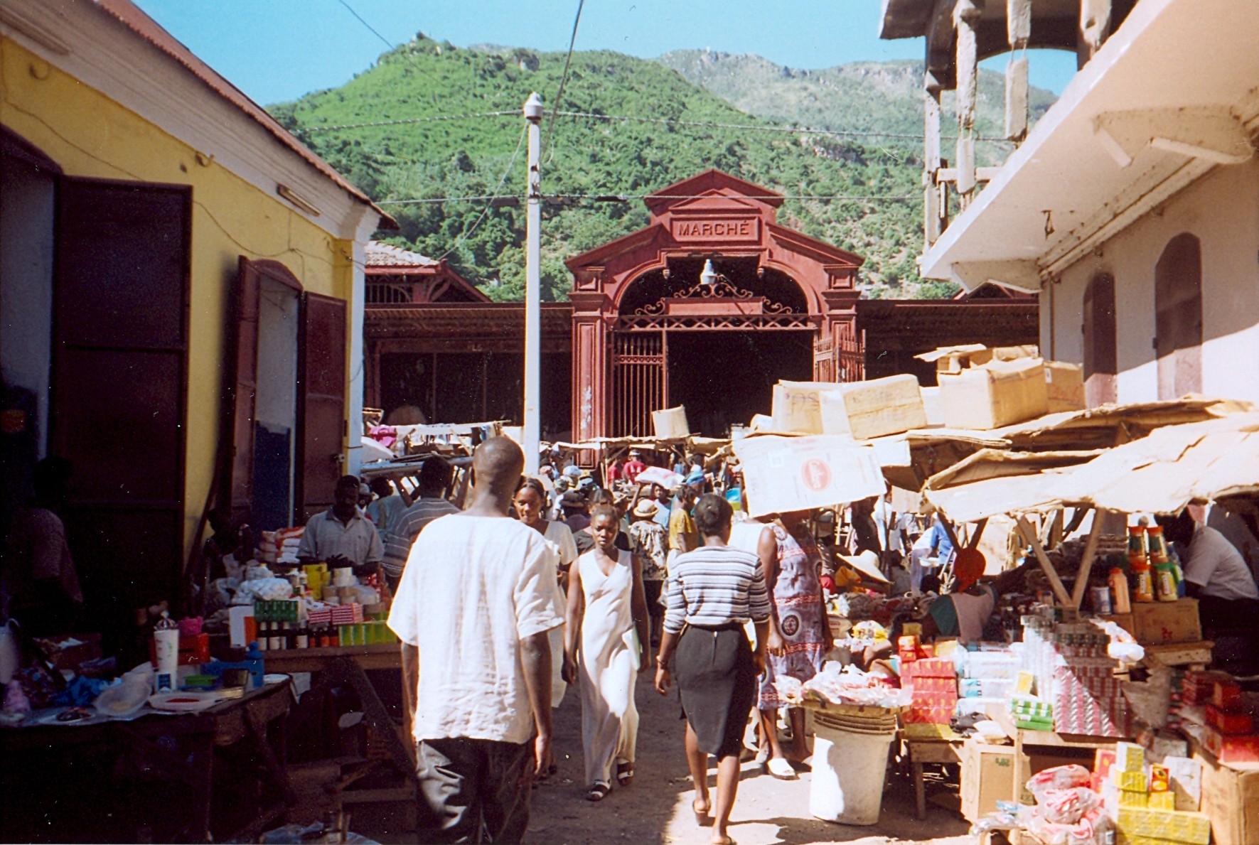 A bustling market scene in Cap-Haïtien. Markets are vital to the Haitian economy, particularly the informal sector.