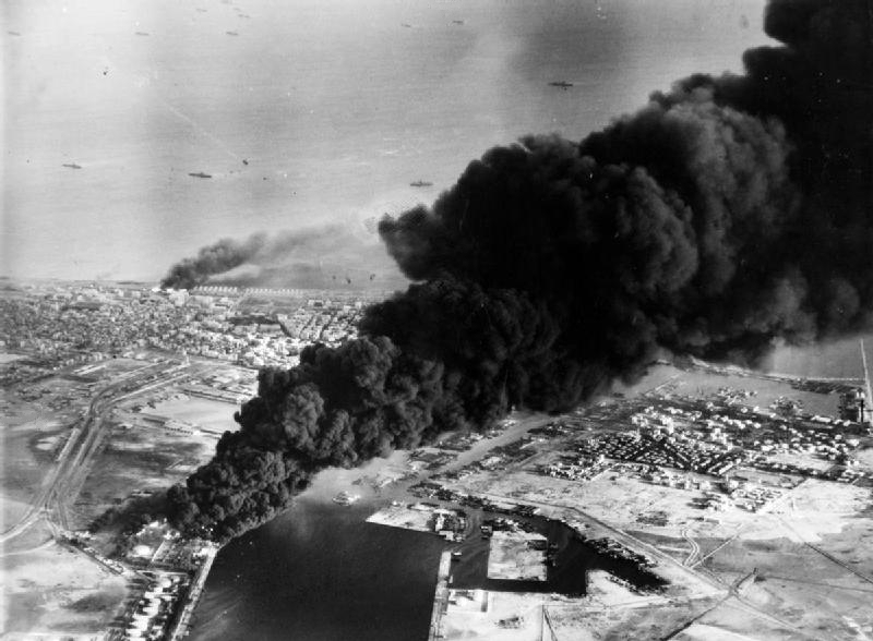 Smoke rises from oil tanks beside the Suez Canal hit during the initial Anglo-French assault on Egypt, 5 November 1956. The crisis solidified Nasser's anti-imperialist stance.