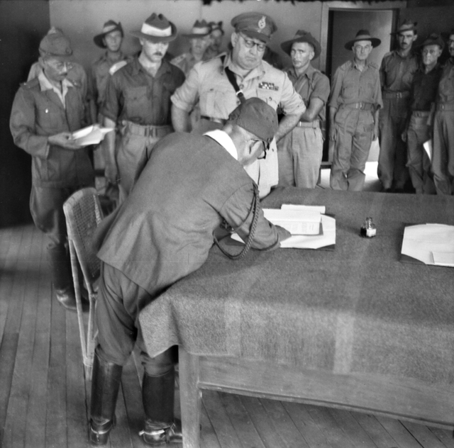 Mejar Jeneral Wootten dari Divisyen Ke-9 Australia bersama Leftenan Jeneral Masao Baba (menandatangani) dari Divisyen Ke-37 Jepun pada upacara penyerahan diri di Labuan pada 10 September 1945