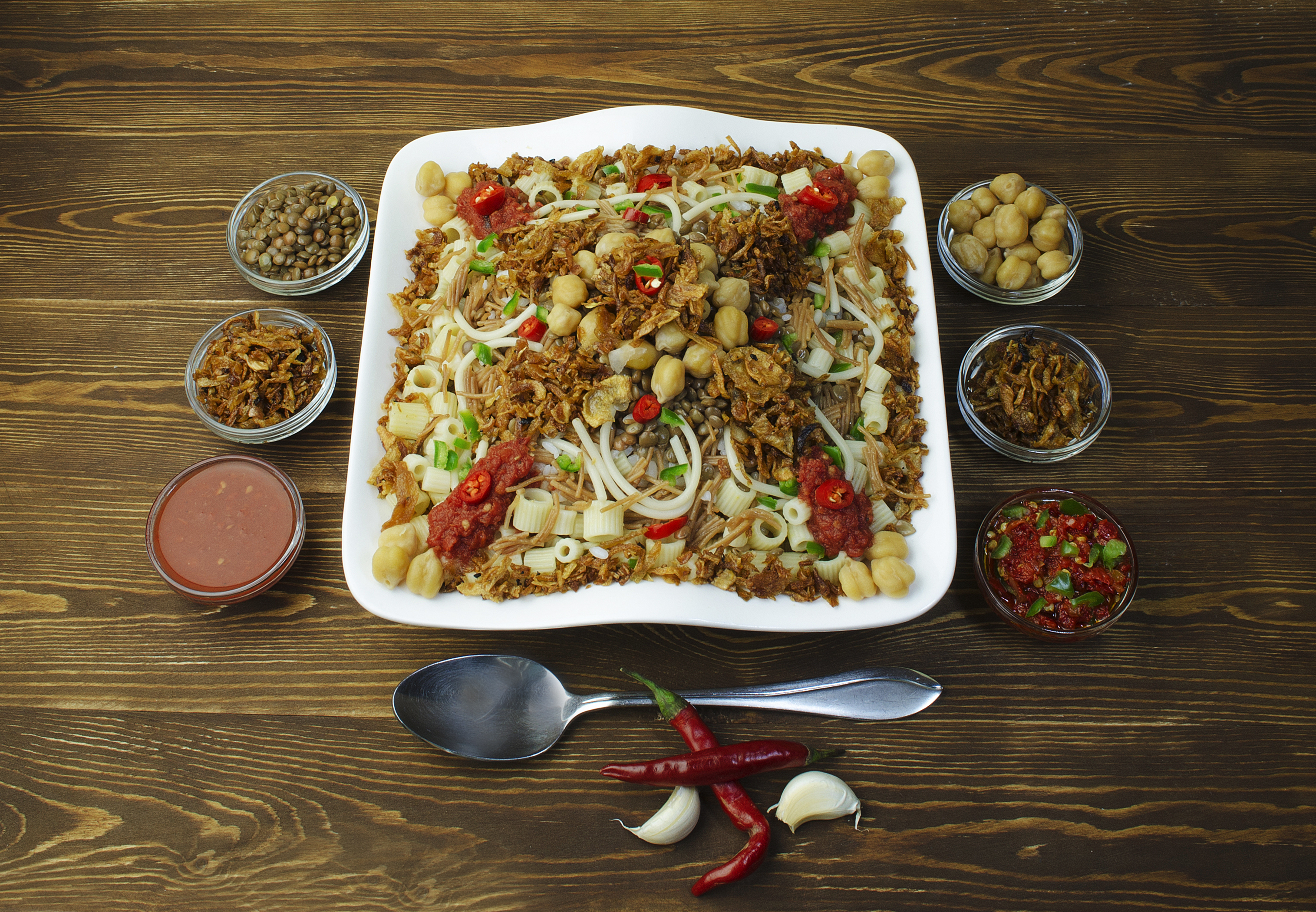 Kushari, a popular and iconic Egyptian national dish made from rice, lentils, and macaroni, topped with a spicy tomato sauce and fried onions.
