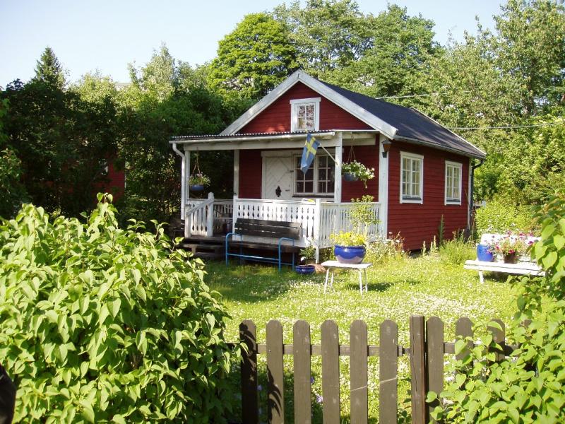 A traditional red wooden house with white trim, common in the Swedish countryside.