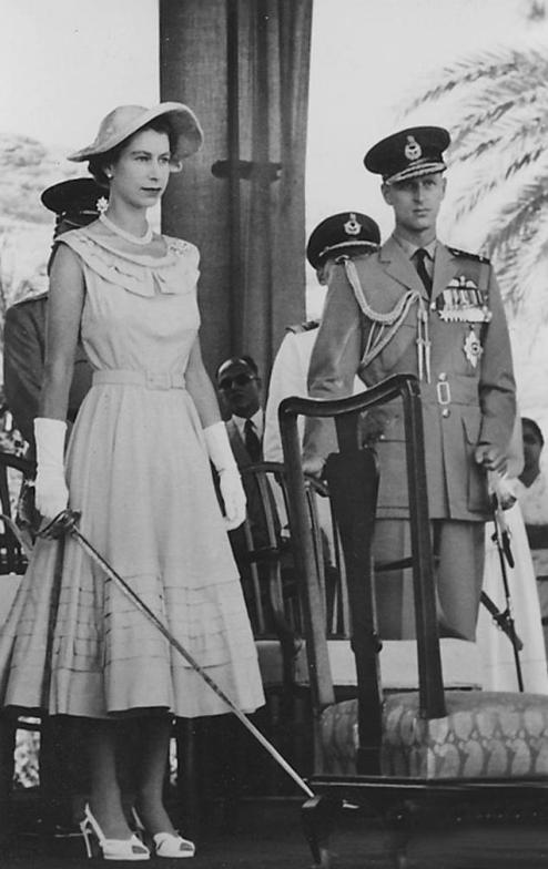 สมเด็จพระราชินีนาถเอลิซาเบธที่ 2 ทรงถือดาบ เตรียมพระราชทานเครื่องราชอิสริยาภรณ์แก่อัศวินในเอเดน ซึ่งเป็นส่วนหนึ่งของการเสด็จเยือนในปี 1954 เจ้าชายฟิลิป ดยุกแห่งเอดินบะระ อยู่ทางด้านขวา
