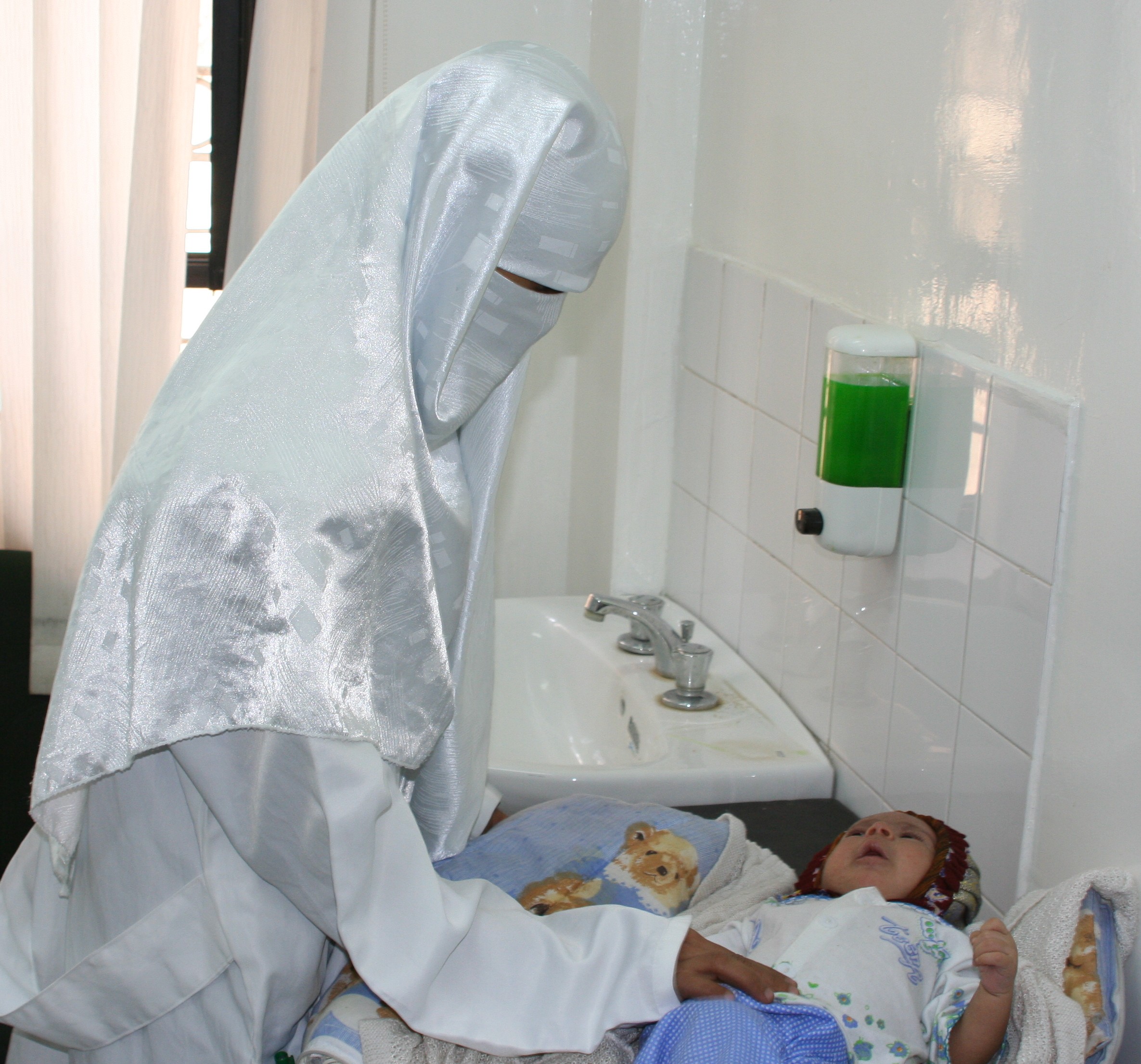 Seorang dokter Yaman memeriksa bayi di klinik perawatan kesehatan yang disponsori USAID.