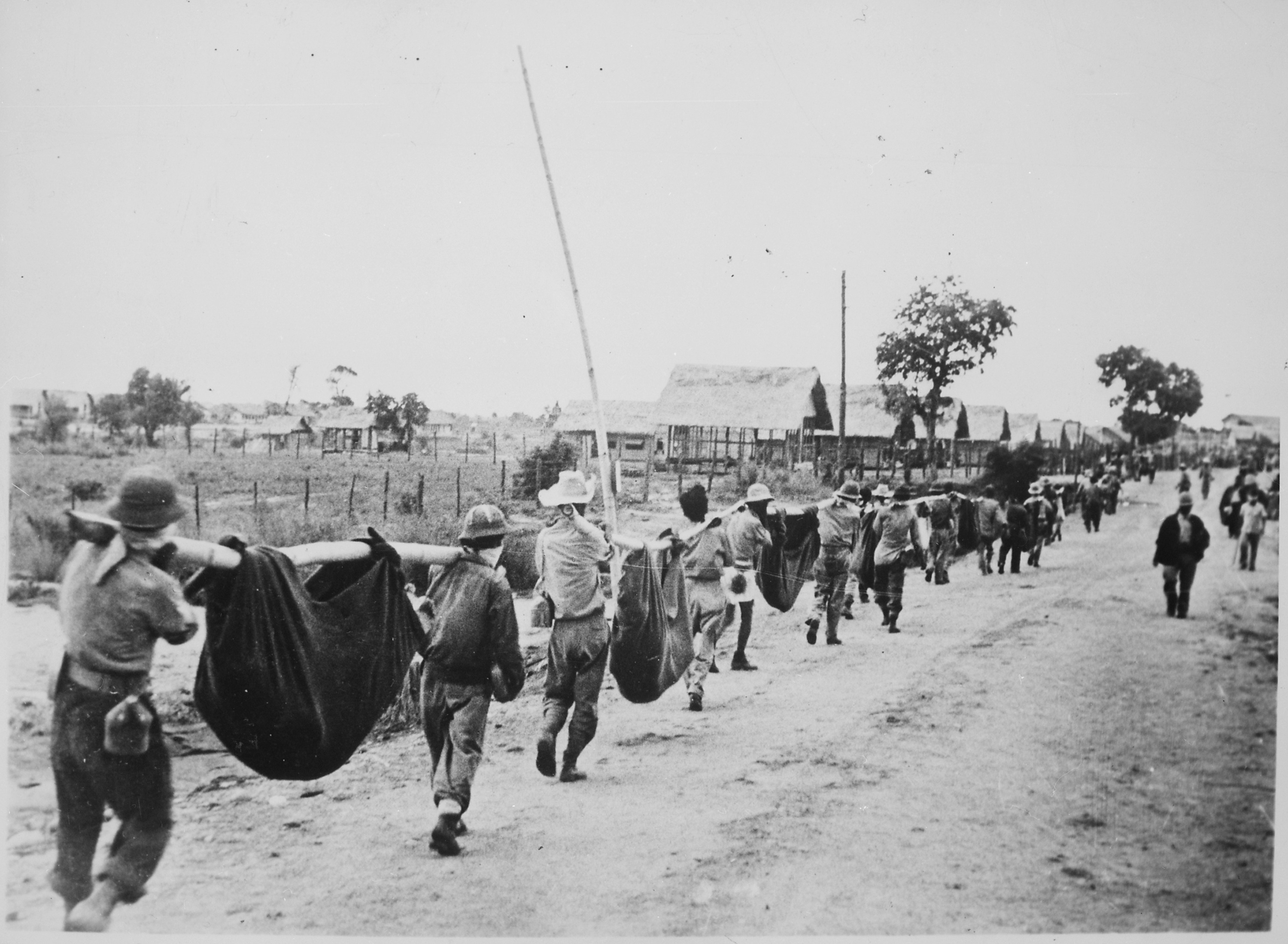 미군과 필리핀군 포로들이 임시 들것을 사용하여 전우를 운반하는 모습 (1942년 5월, [[바탄 죽음의 행진]])
