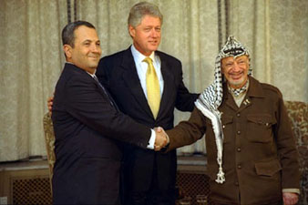 Arafat (kanan) berjabat tangan dengan Barak (tengah ialah Bill Clinton)