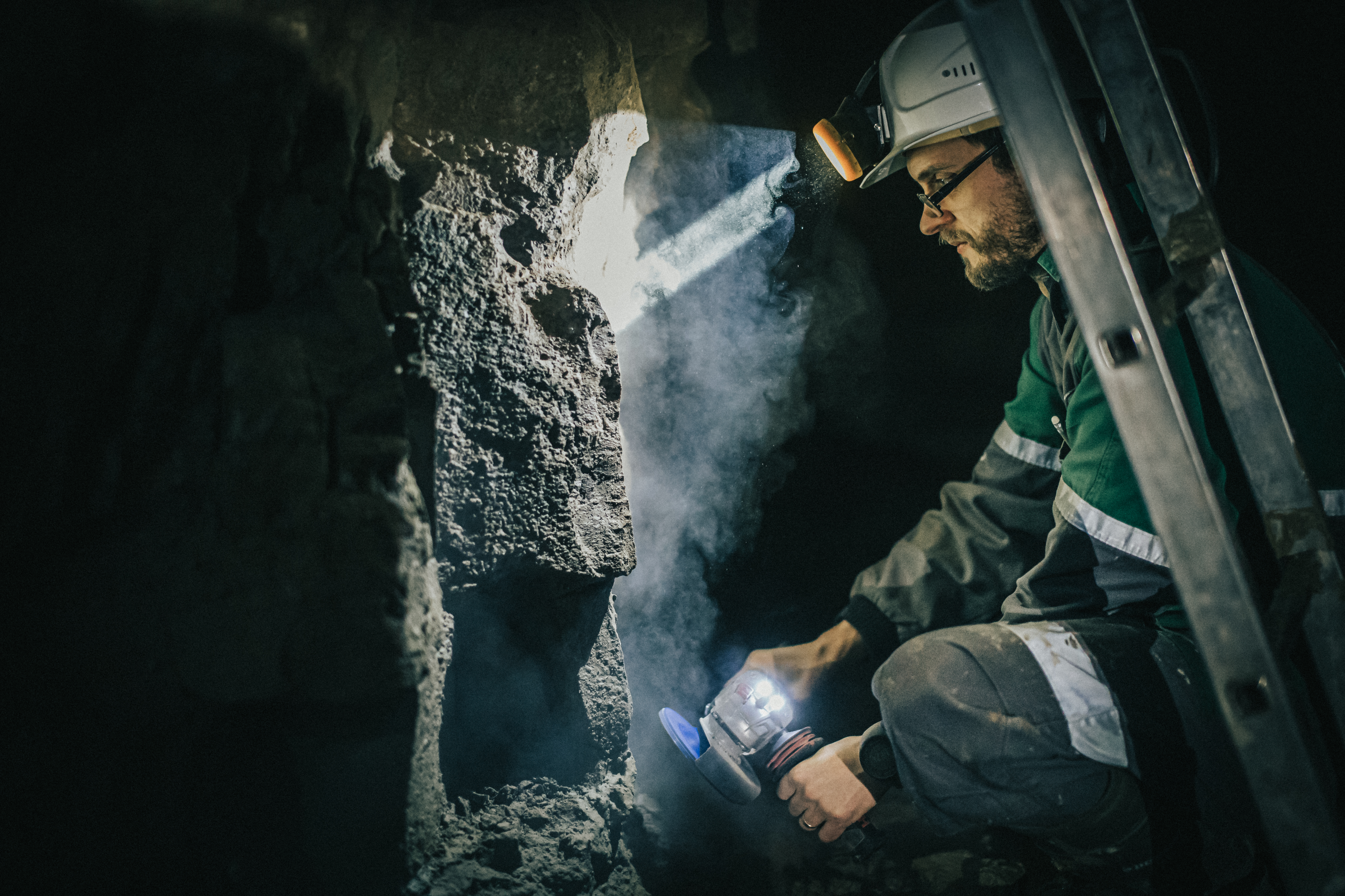 An Estonian underground miner conducts fieldwork to study oil shale reserves. The oil shale industry has significant economic and social importance in northeastern Estonia but also poses environmental challenges.