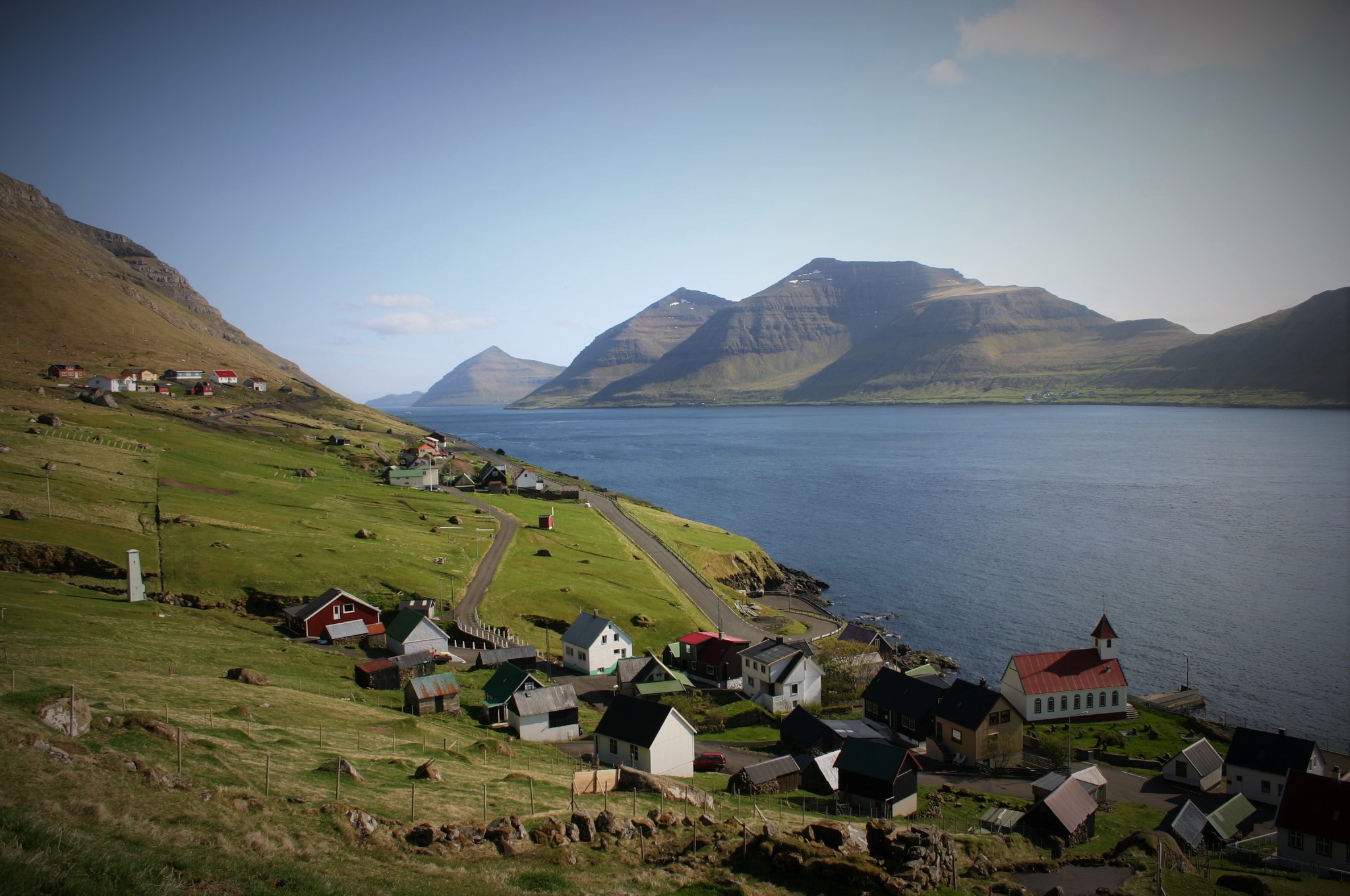 The village of Kunoy on Kunoy island, in the Faroe Islands. These autonomous territories have distinct identities and extensive self-governance within the Kingdom of Denmark.