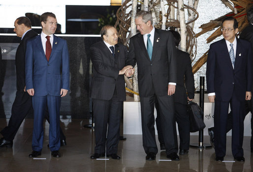 Presiden Abdelaziz Bouteflika dan George W. Bush berjabat tangan di Windsor Hotel Toya Resort and Spa di Kota Tōyako, Distrik Abuta, Hokkaidō pada tahun 2008. Bersama mereka adalah Dmitry Medvedev, kiri, dan Yasuo Fukuda, kanan.