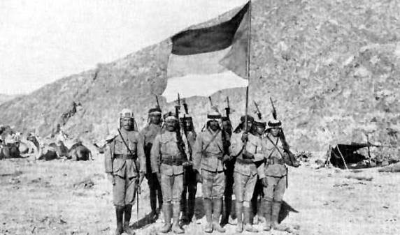Prajurit Tentara Arab yang dipimpin Hasyimiyah memegang bendera Pemberontakan Arab Besar melawan Kesultanan Utsmaniyah di Hijaz, 1916