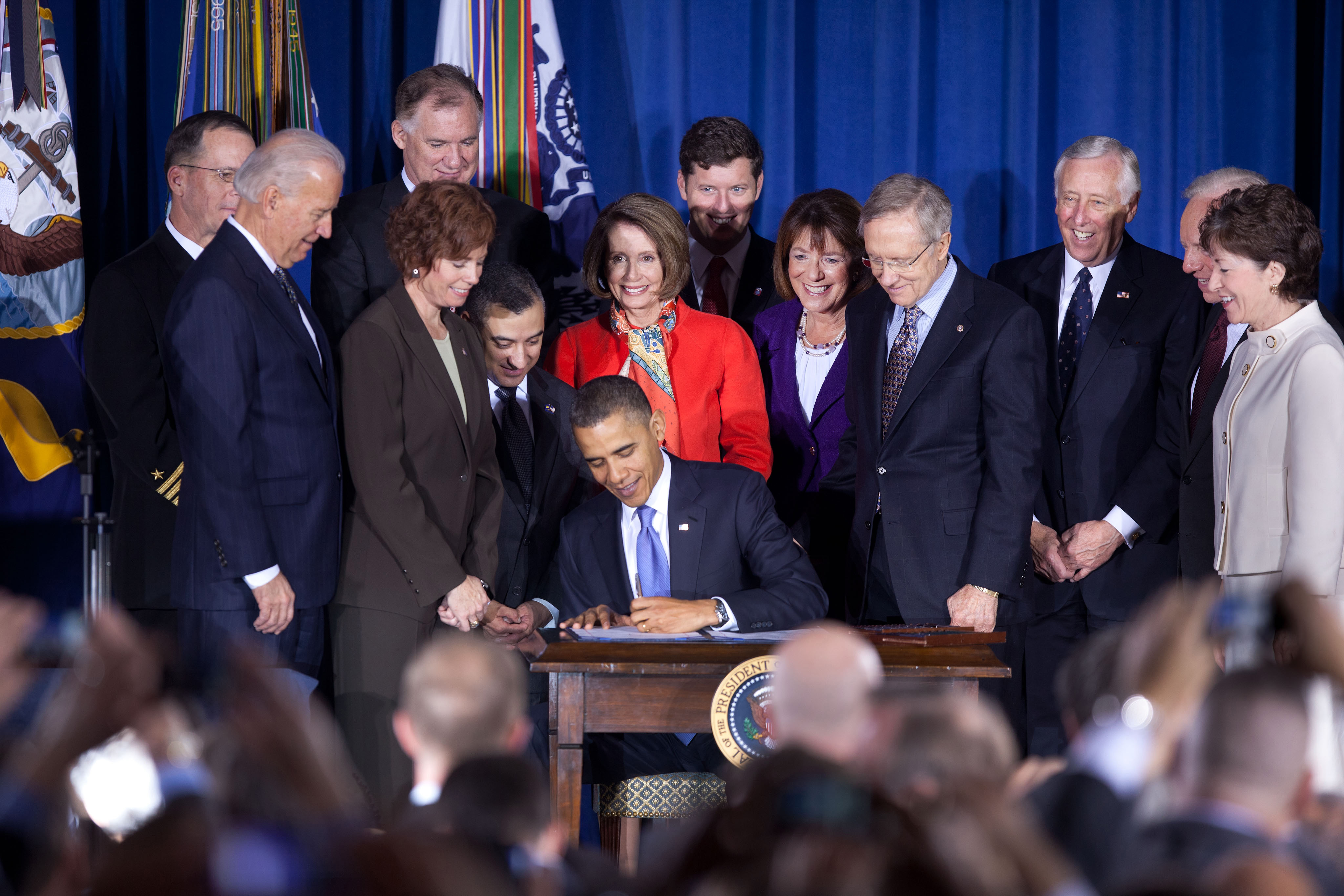 Reid stands near President Barack Obama as he signs the repeal of Don't Ask Don't Tell in 2010.