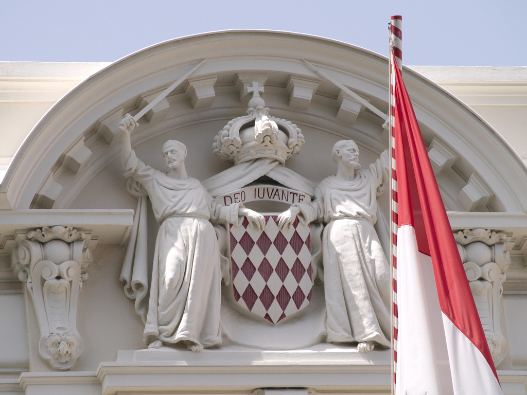 The flag of Monaco alongside its coat of arms.