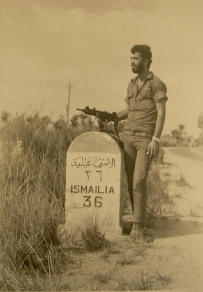 ISMAILIA 36이라는 도로 표지판 옆에서 우지를 든 군인