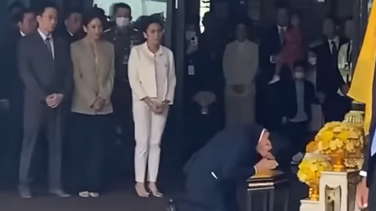 돈므앙 국제공항에서 15년 만에 태국 귀국 후 왕실 초상화에 경의를 표하는 탁신