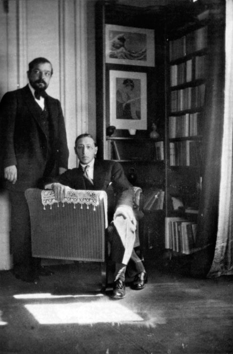 1910年に撮影されたクロード・ドビュッシーとイーゴリ・ストラヴィンスキー。背景に「神奈川沖浪裏」などの絵画が飾られている。