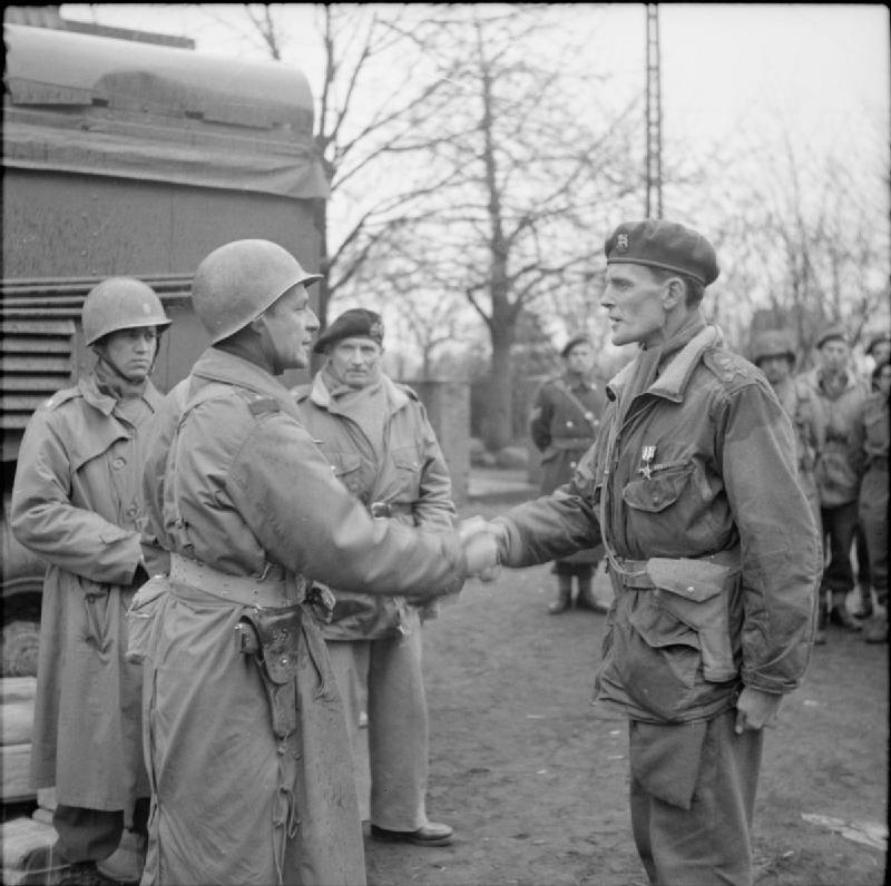 リッジウェイ(左)が英国のジェームズ・ヒル准将にシルバースターを授与する様子(1945年3月)。中央にはバーナード・モントゴメリー元帥も写っている。