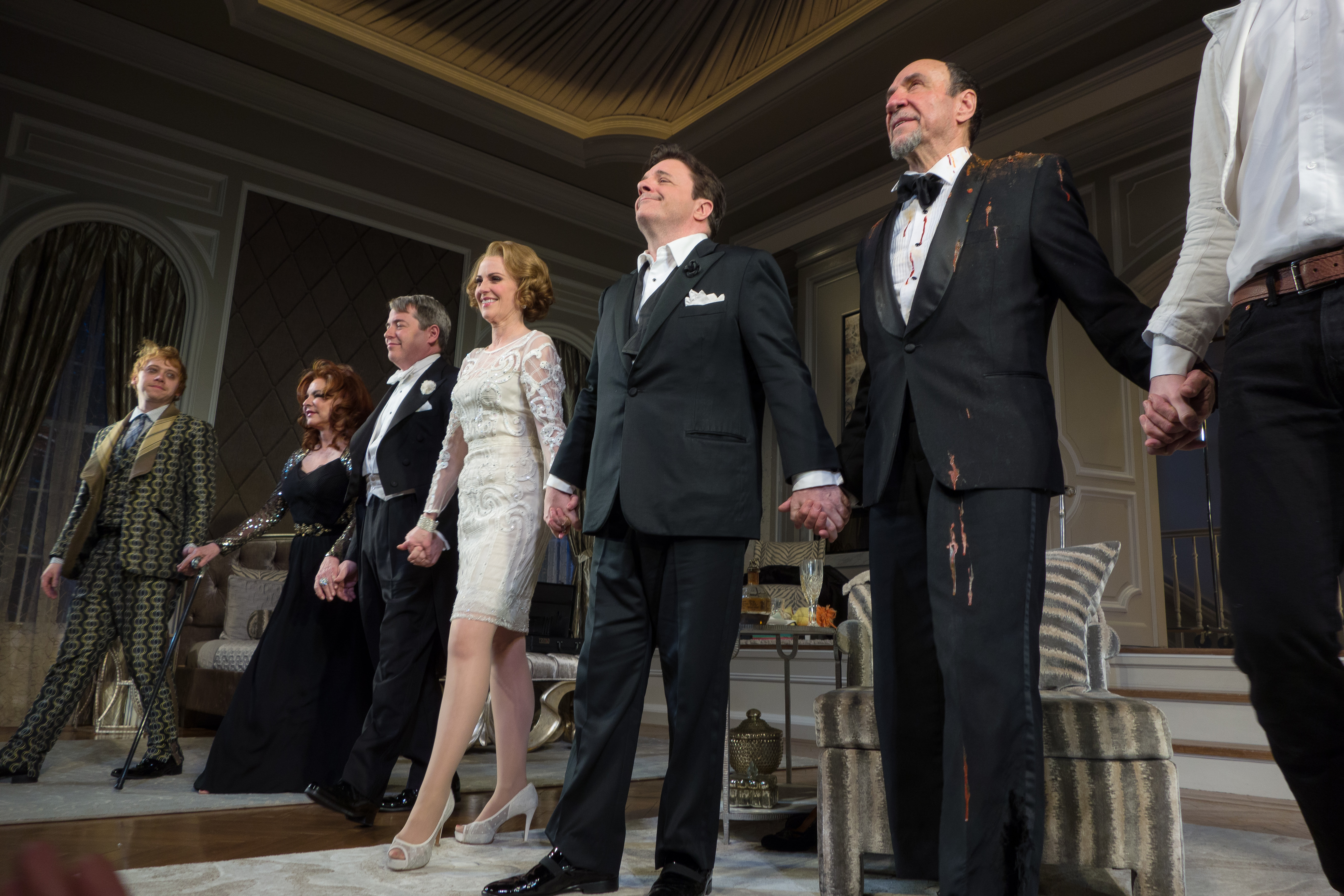 The cast holding hands onstage