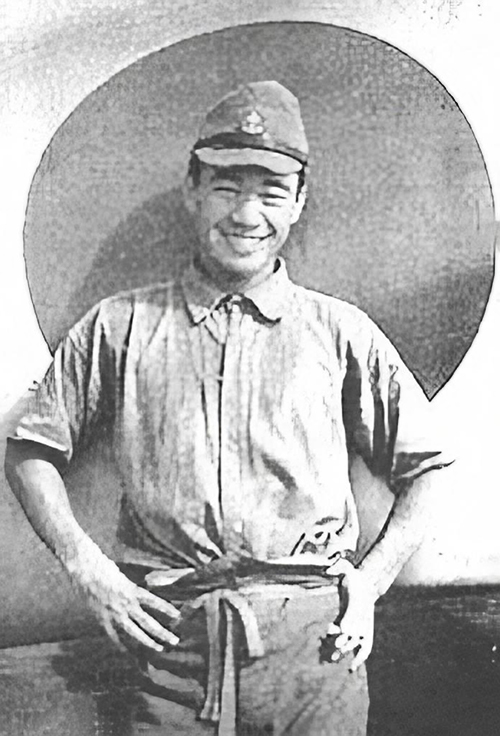 1939年、九六式艦上戦闘機の日の丸の前でポーズをとる若き日の坂井