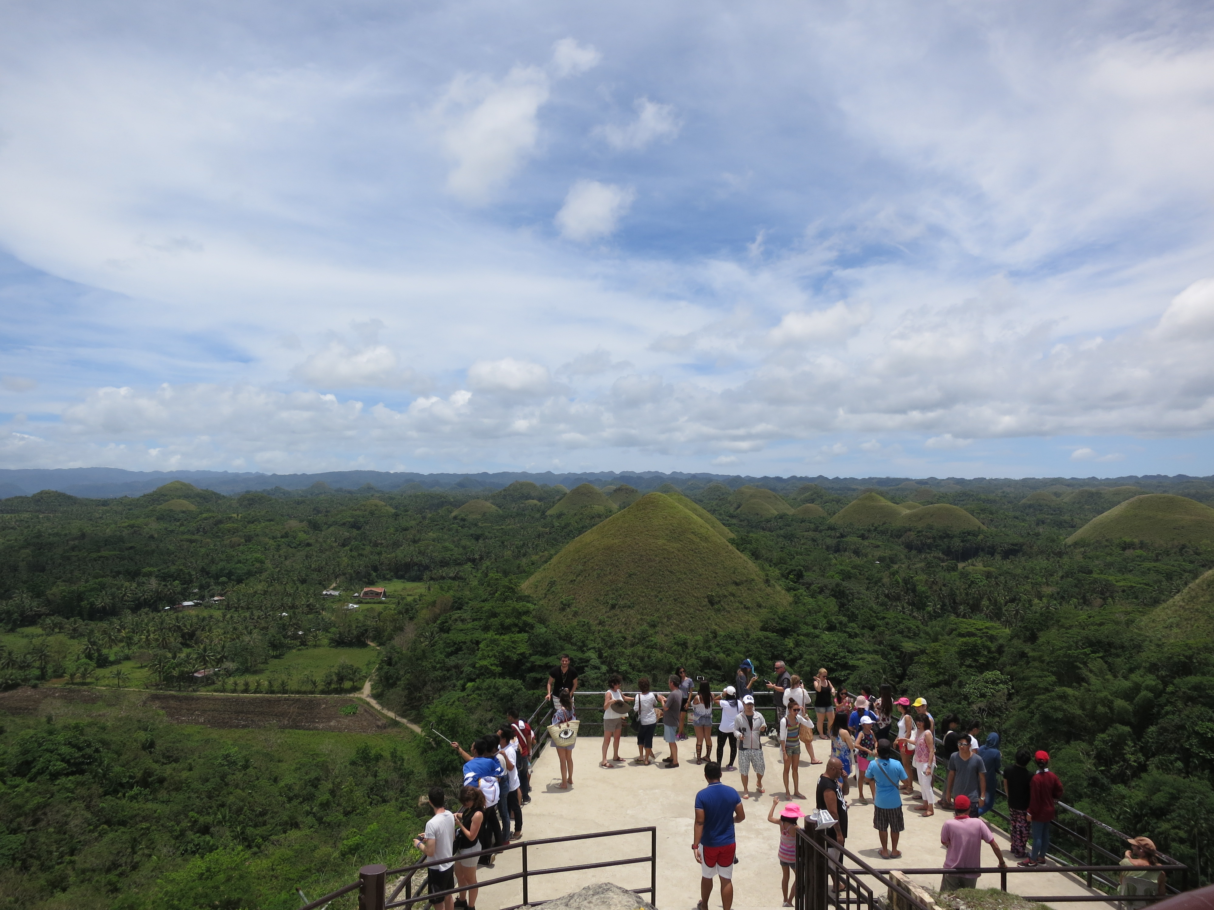 Tourists at the Chocolate Hills viewing deck in Bohol. These unique geological formations are a major tourist attraction.