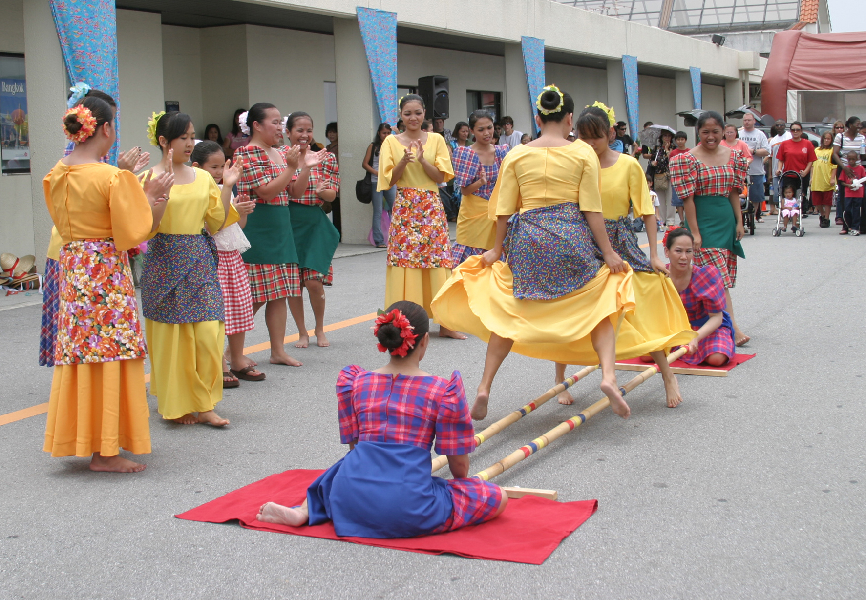 Tinikling, a traditional Philippine folk dance that imitates the movements of the tikling bird as it gracefully navigates between bamboo traps. It is characterized by dancers stepping over and in between bamboo poles clapped together in a rhythmic pattern.