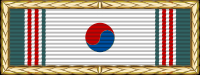 가장자리에 녹색과 빨간색 줄무늬가 있고 가운데에 빨간색과 파란색 원이 있는 흰색 리본