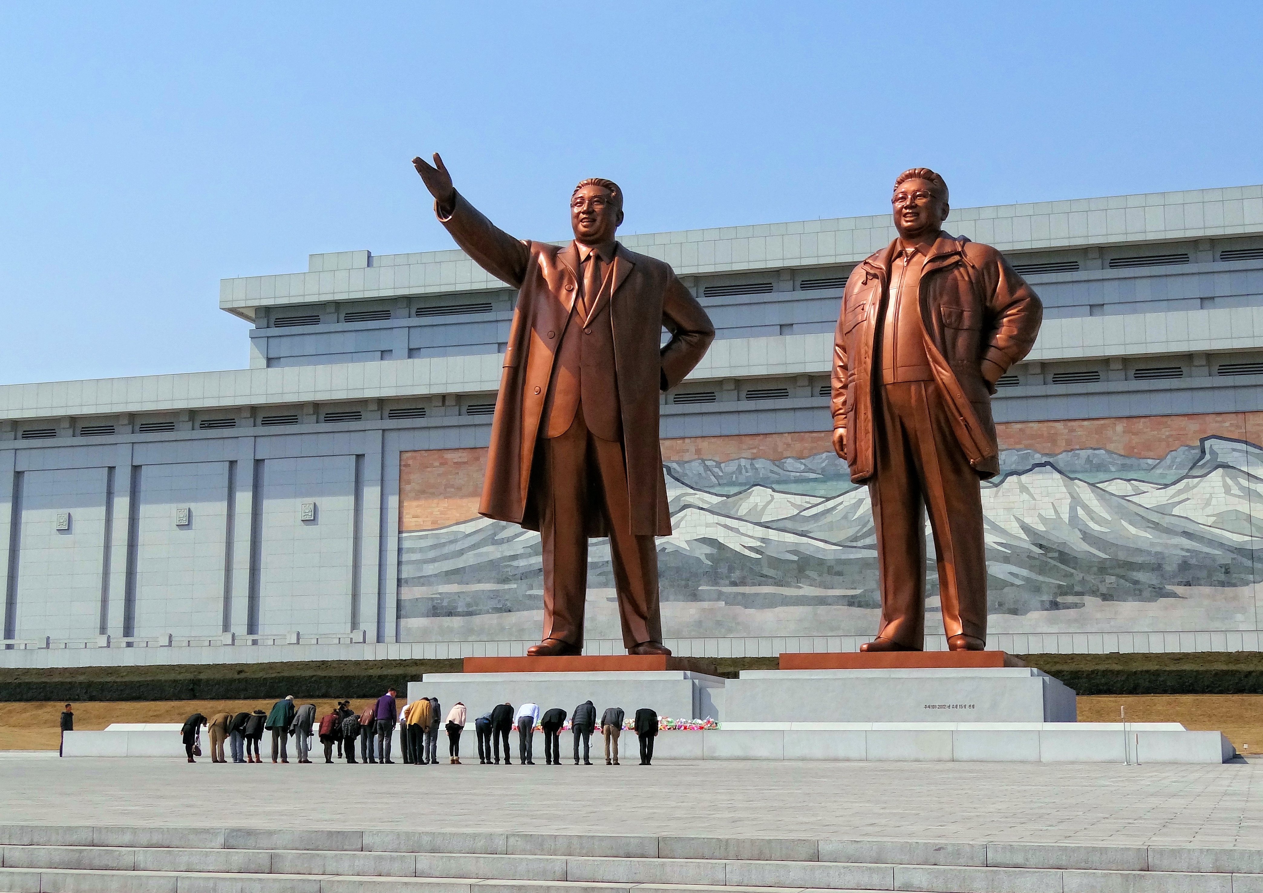 North Korean citizens paying respect to the statues of Kim Il Sung (left) and Kim Jong Il at the Mansu Hill Grand Monument