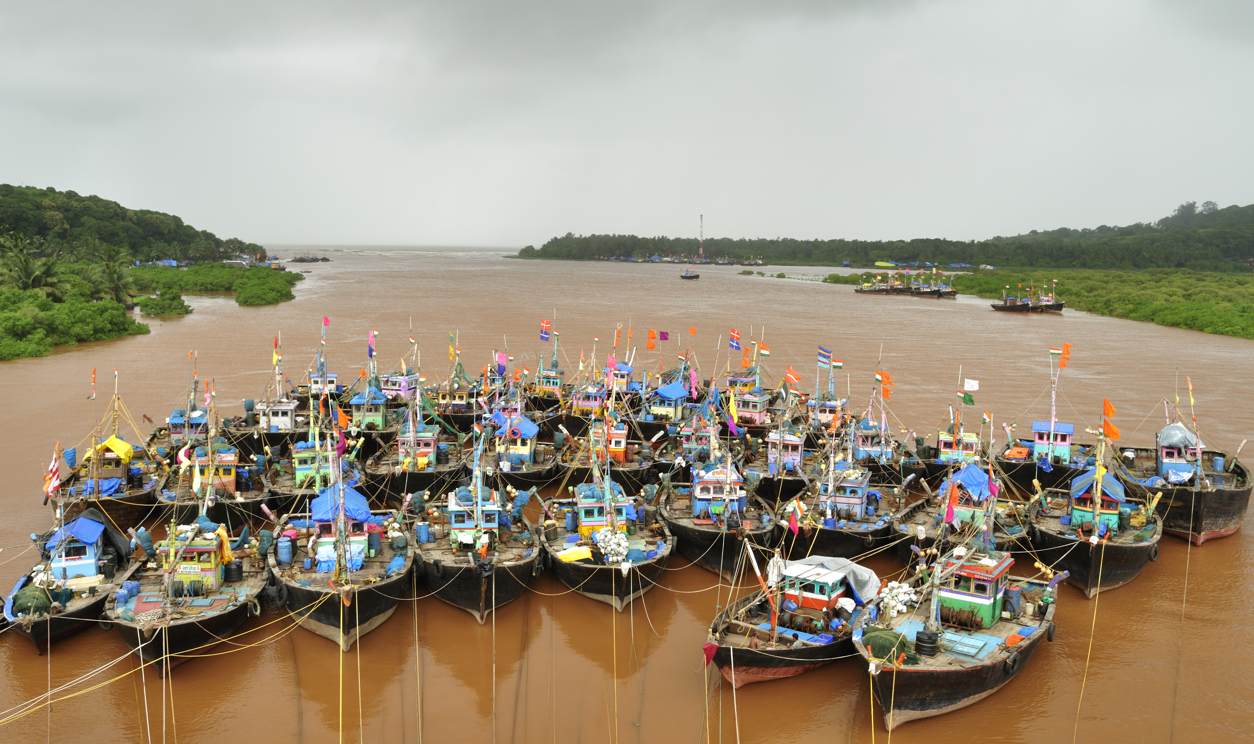 Fishing boats lashed together in a tidal creek in Anjarle village, Maharashtra, on the Konkan Coast, representing coastal livelihoods.