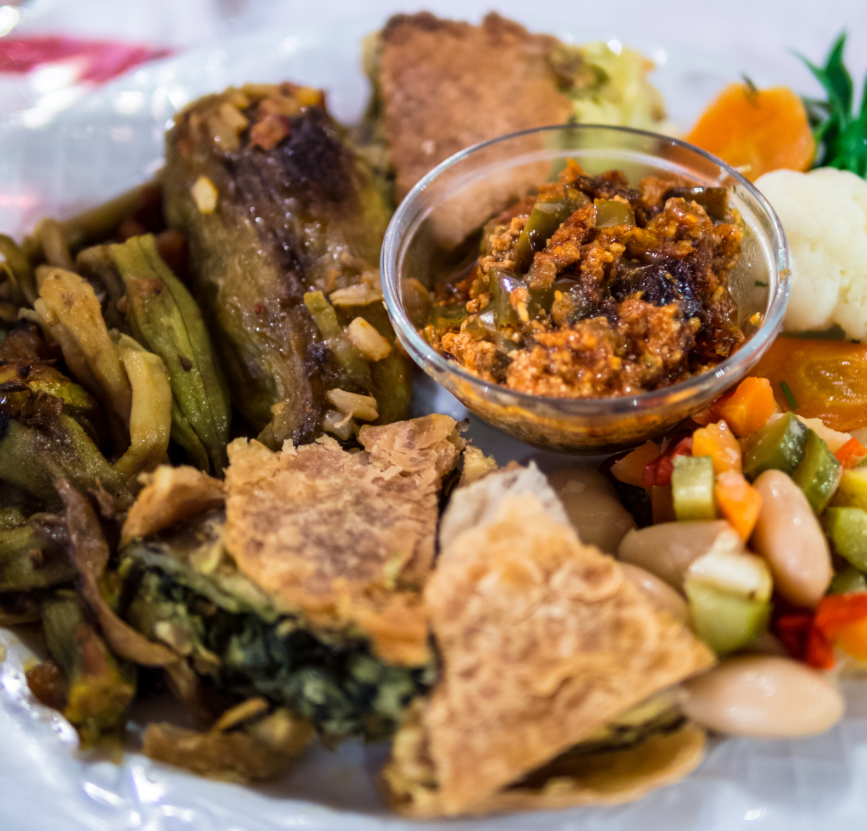Speca të fërguar (roasted peppers) served with pite, a traditional and prominent layered Albanian pie.