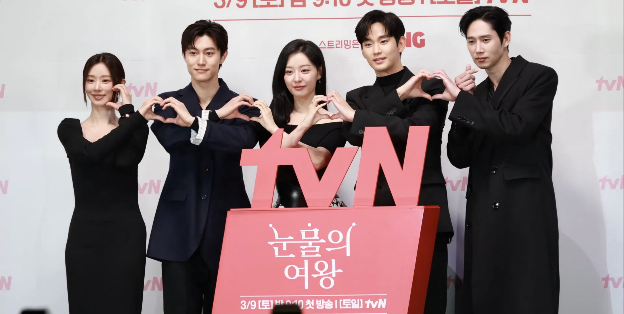 시리즈의 주요 출연진이 기자 회견에서 손 하트를 하고 있다.