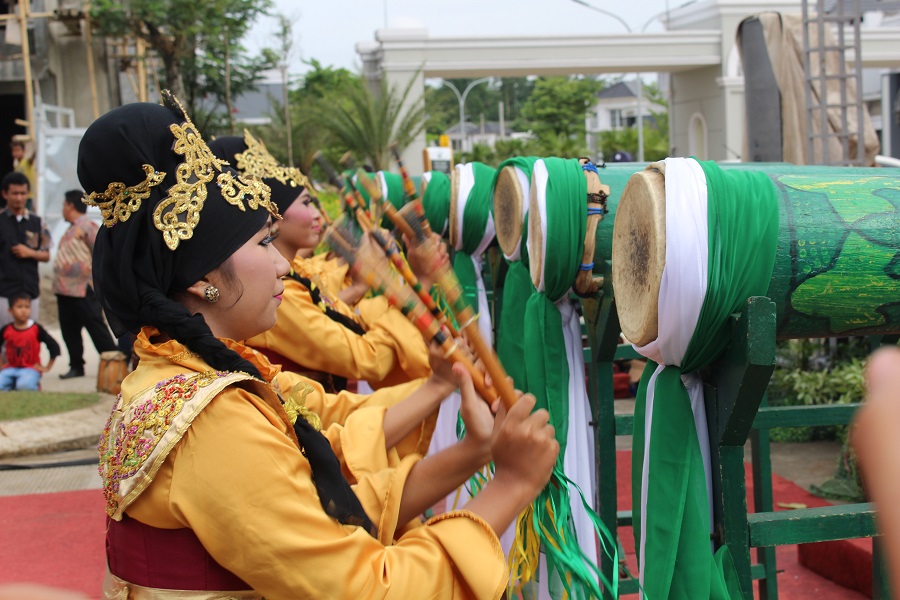 Women in yellow playing green drums