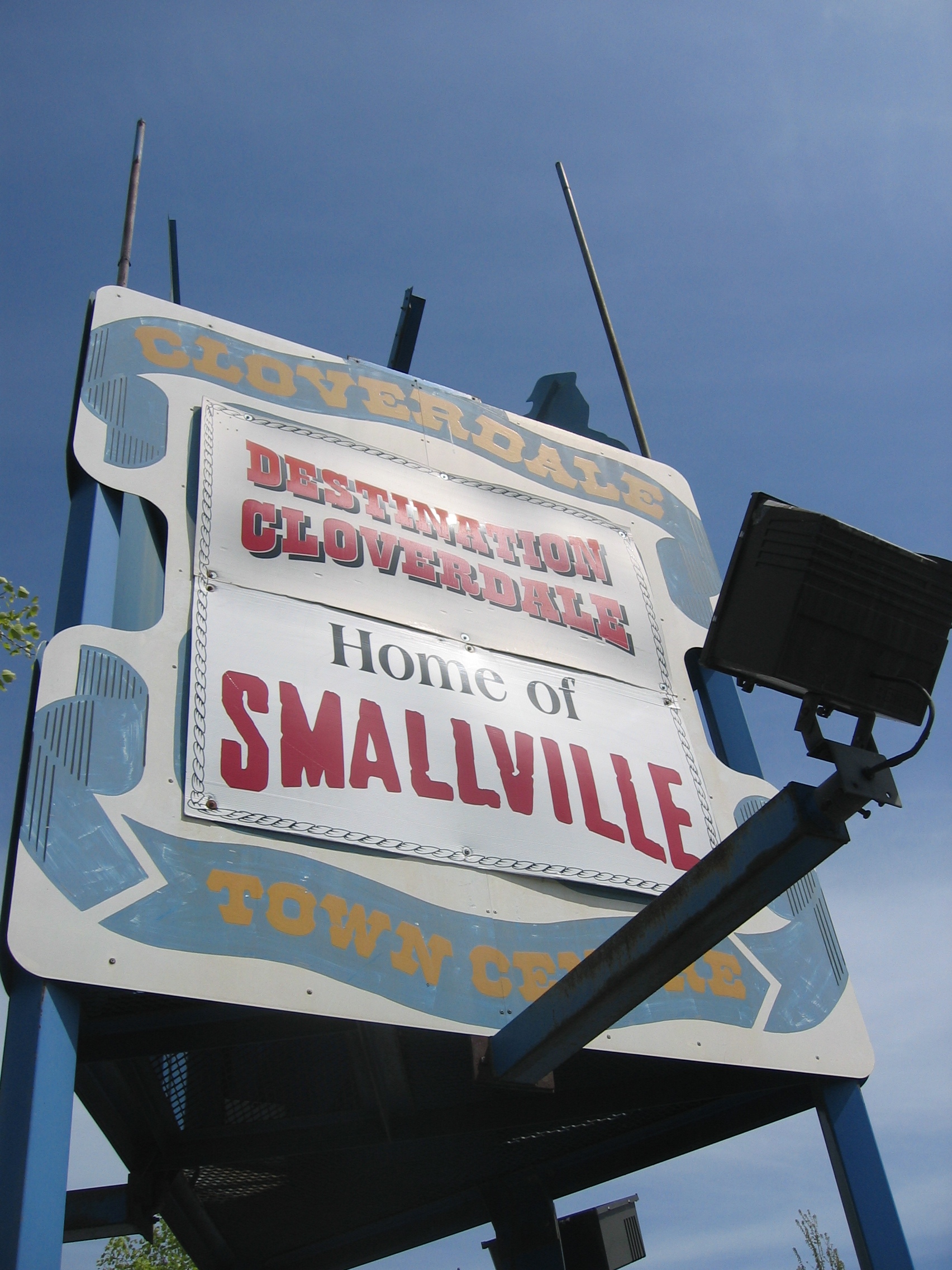 A white billboard with a blue ribbon around the edges. On the ribbon, 
