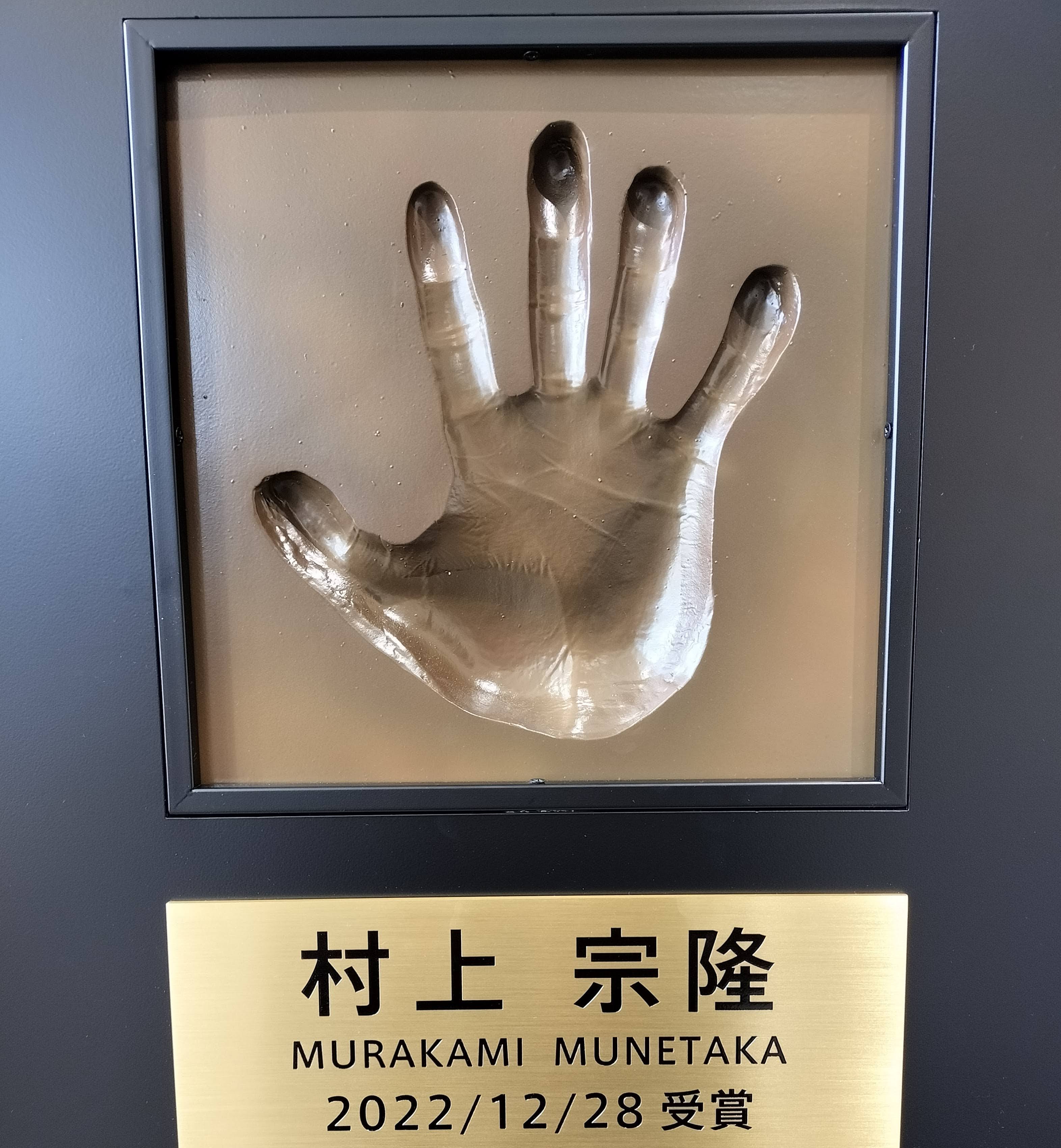 รอยพิมพ์มือของมุเนะทากะ มูราคามิ ที่จัดแสดงในล็อบบี้ชั้น 1 ของสำนักงานจังหวัดคุมาโมโตะ