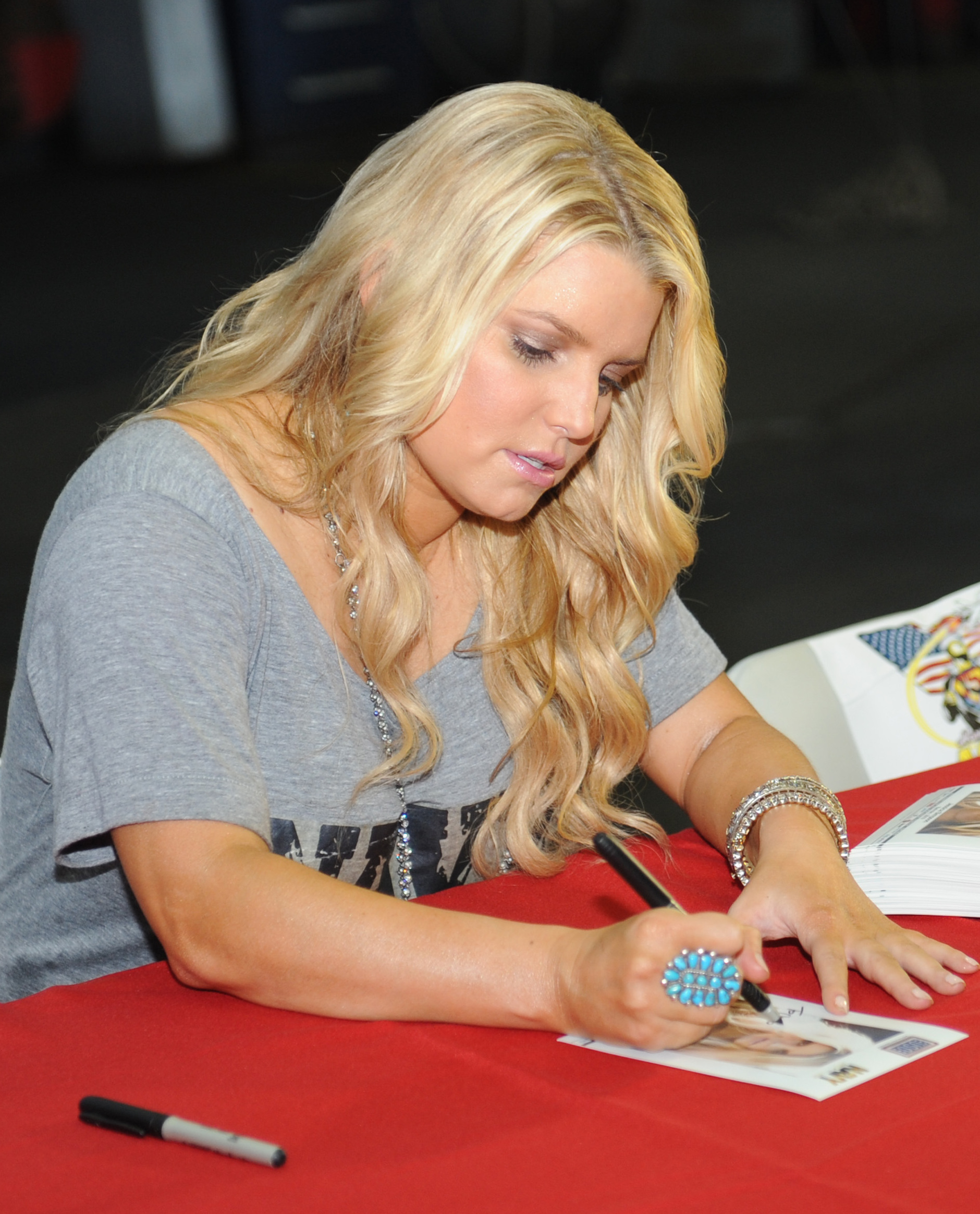 Jessica Simpson menandatangani foto untuk seorang Pelaut selama kunjungan yang disponsori USO dan Navy Entertainment di atas kapal USS Harry S. Truman pada tahun 2010.