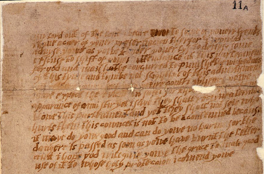 A damaged and aged piece of paper, or parchment, with multiple lines of handwritten English text.