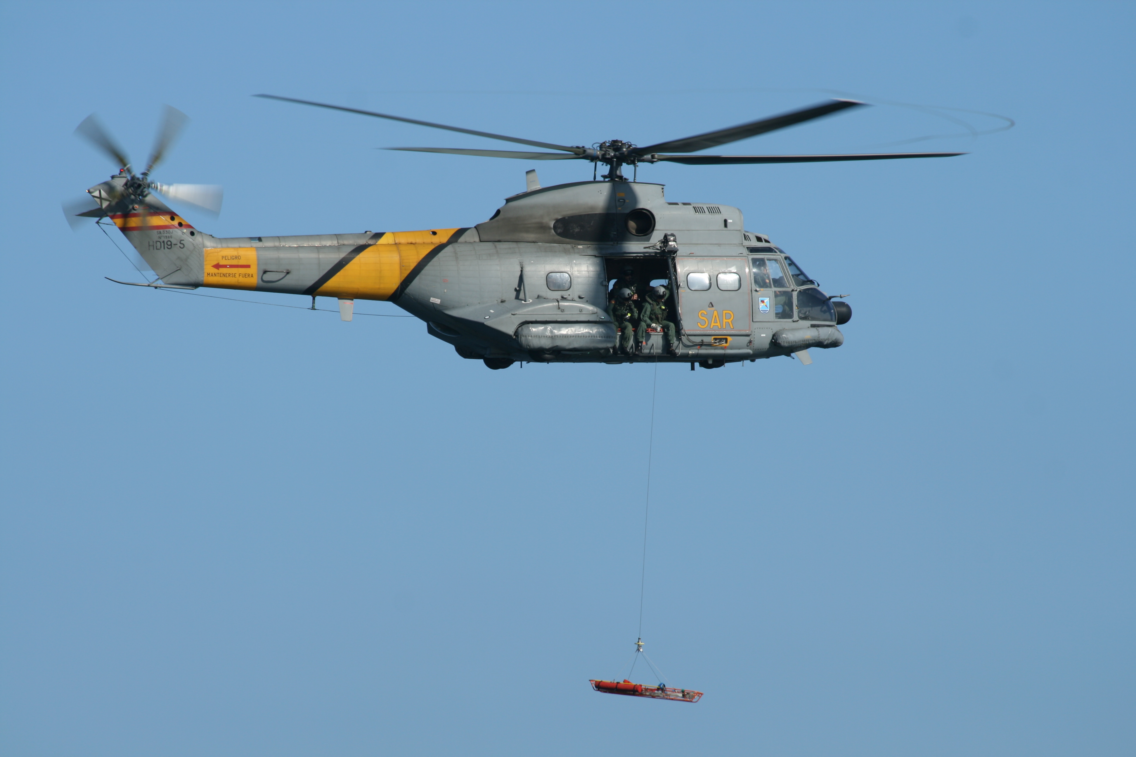 스페인 공군 801 비행대의 Aérospatiale SA330J Puma가 에어쇼에서 비행하고 있다. 호이스트로 들것을 들어 올리고 있다. 헬리콥터 측면에는 군용 회색 색상에 노란색으로 