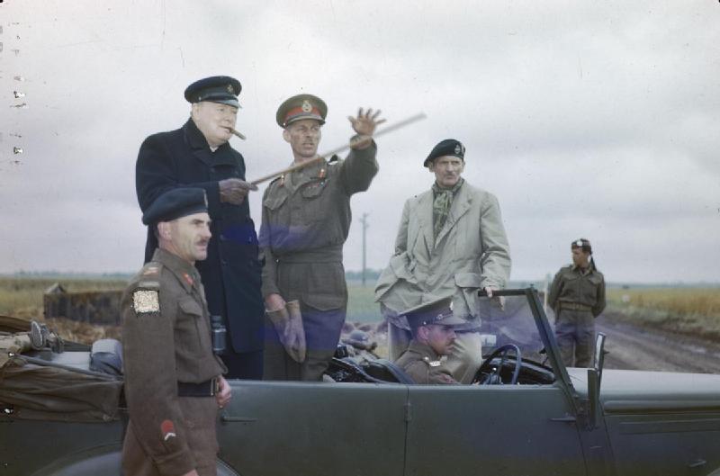 1944년 7월 22일 노르망디 캉 방문 중 윈스턴 처칠에게 전선 일부를 가리키는 뎀프시. 가이 시몬즈(왼쪽)와 몽고메리(오른쪽)가 지켜보고 있다.