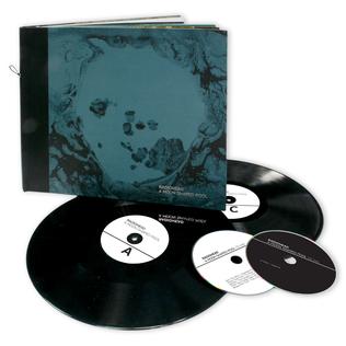 하드북 앨범 커버와 여러 개의 바이닐 레코드와 CD