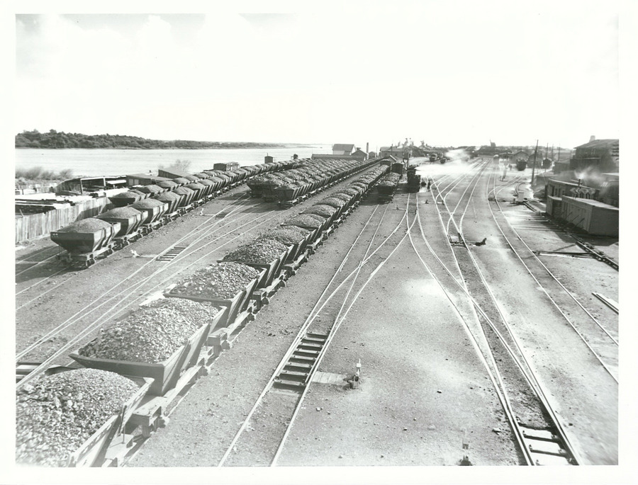 Loaded rail coal trucks, rail tracks and the river on the left