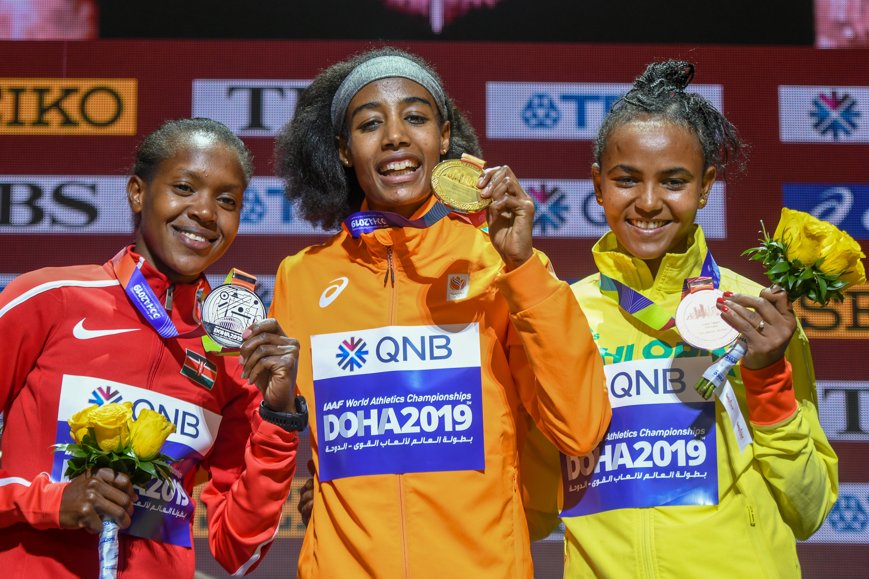 Gudaf Tsegay (left) with Sifan Hassan (center) and Faith Kipyegon (right) on the podium after the 1500m final at the 2019 World Championships.