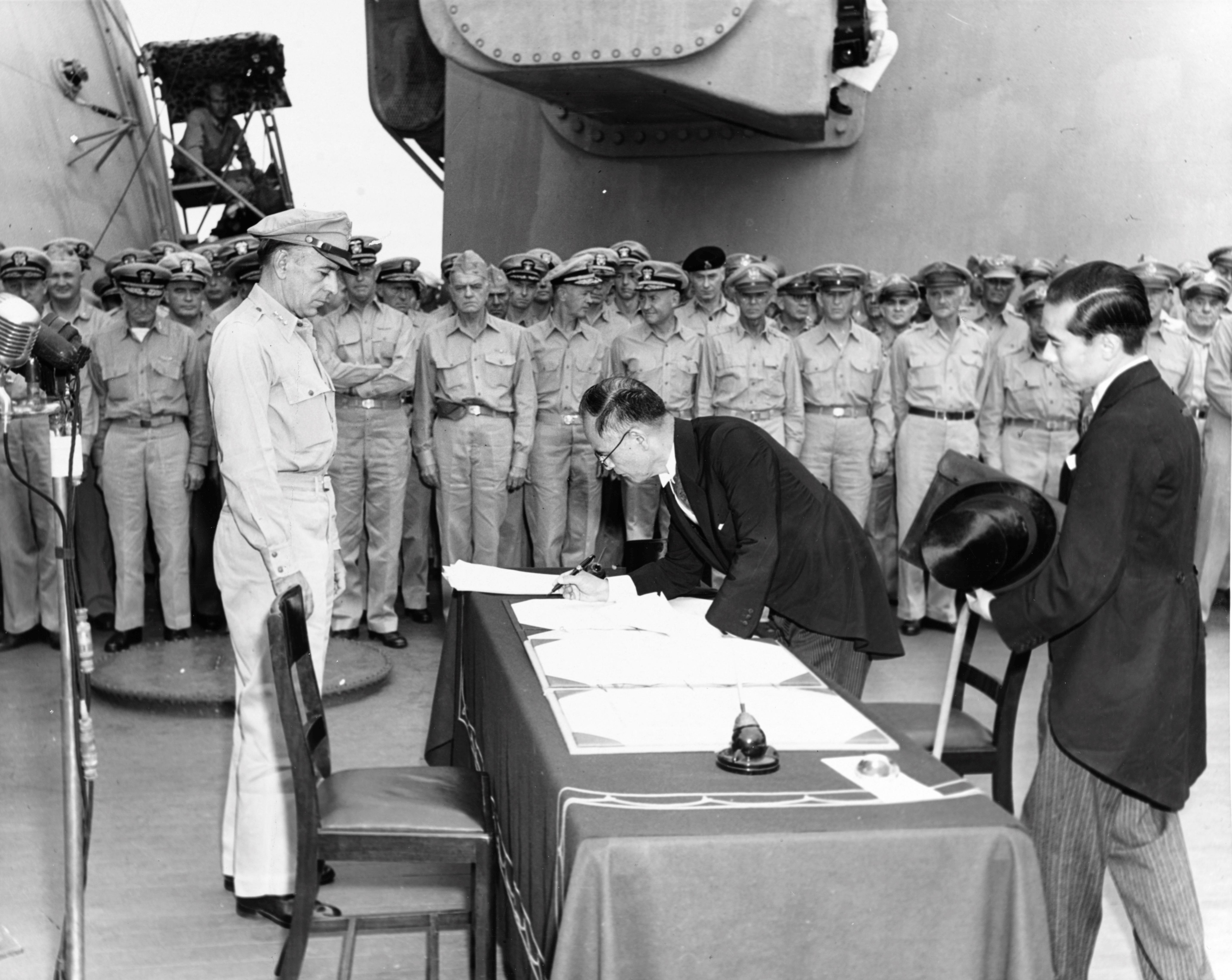 Shigemitsu signs the Japanese Instrument of Surrender at the end of World War II, accompanied by Toshikazu Kase (right).