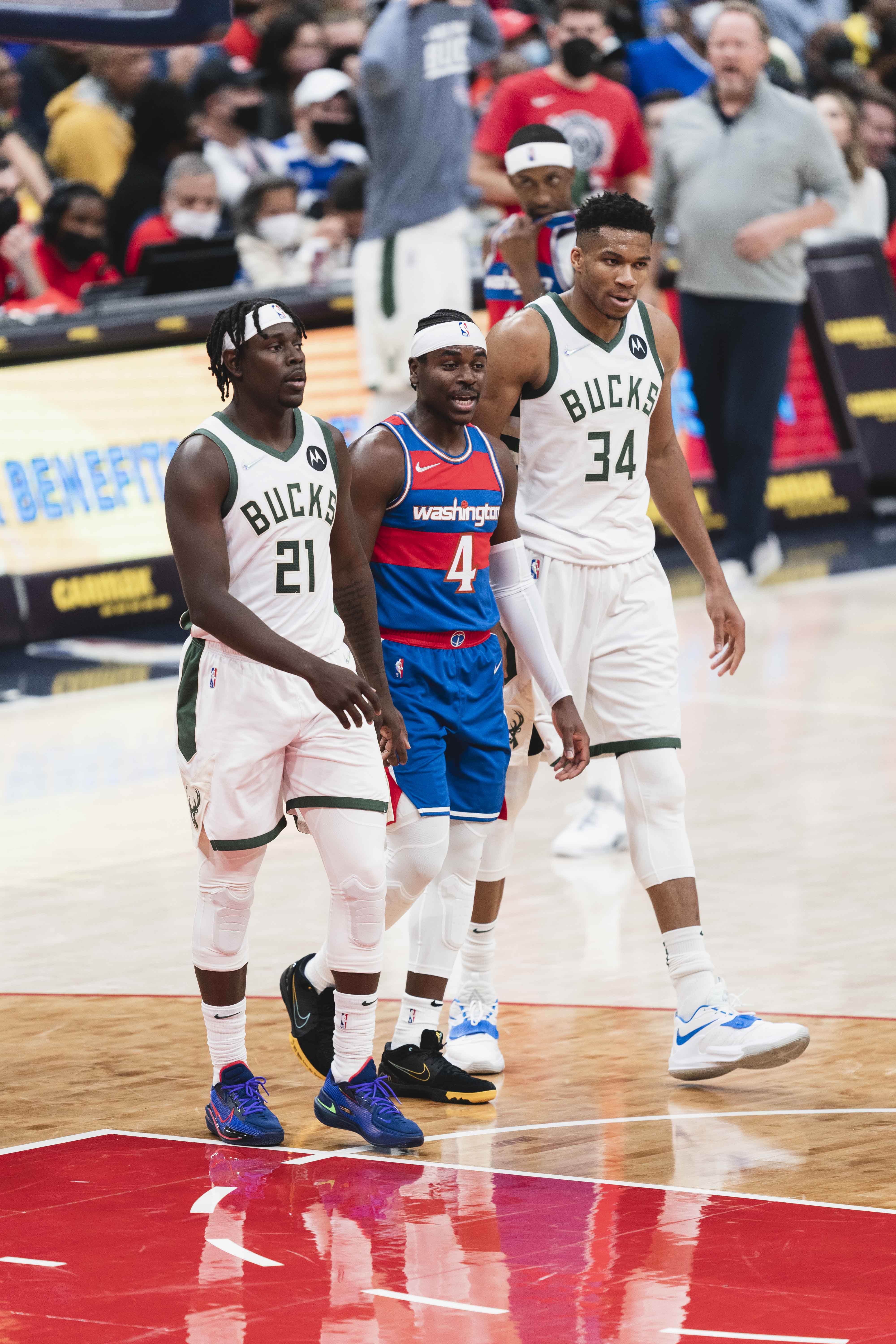 Holiday (kiri) bersama saudaranya Aaron (tengah) dari Washington Wizards pada tahun 2021