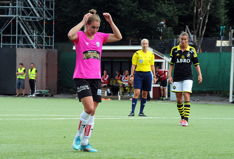 Woman in pink and black football kit