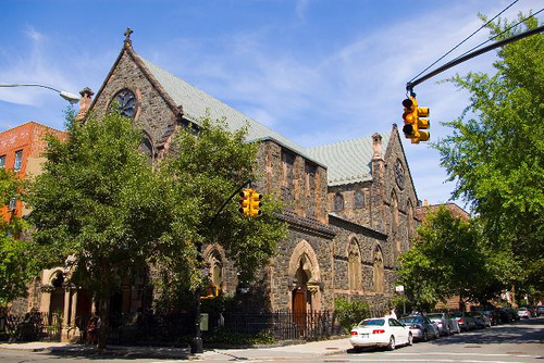 브루클린 캐럴 가든에 있는 세인트 폴 교회(St. Paul's Church)의 길 건너편에서 찍은 모습. 작은 스테인드글라스 창문과 회색 지붕이 있는 벽돌 건물