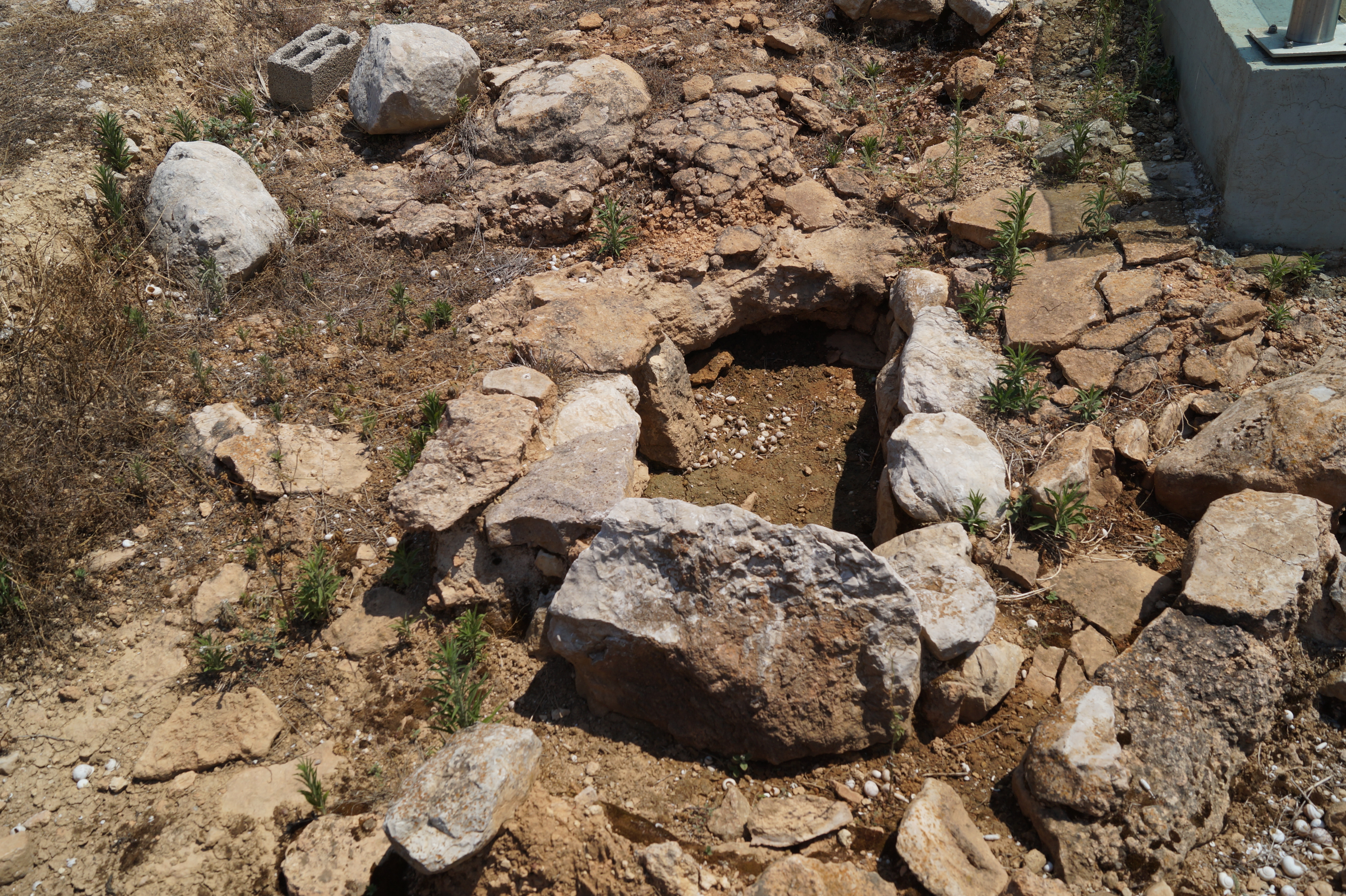 돌 조각으로 가장자리를 두른 사각형 구멍으로 건설된 작은 무덤