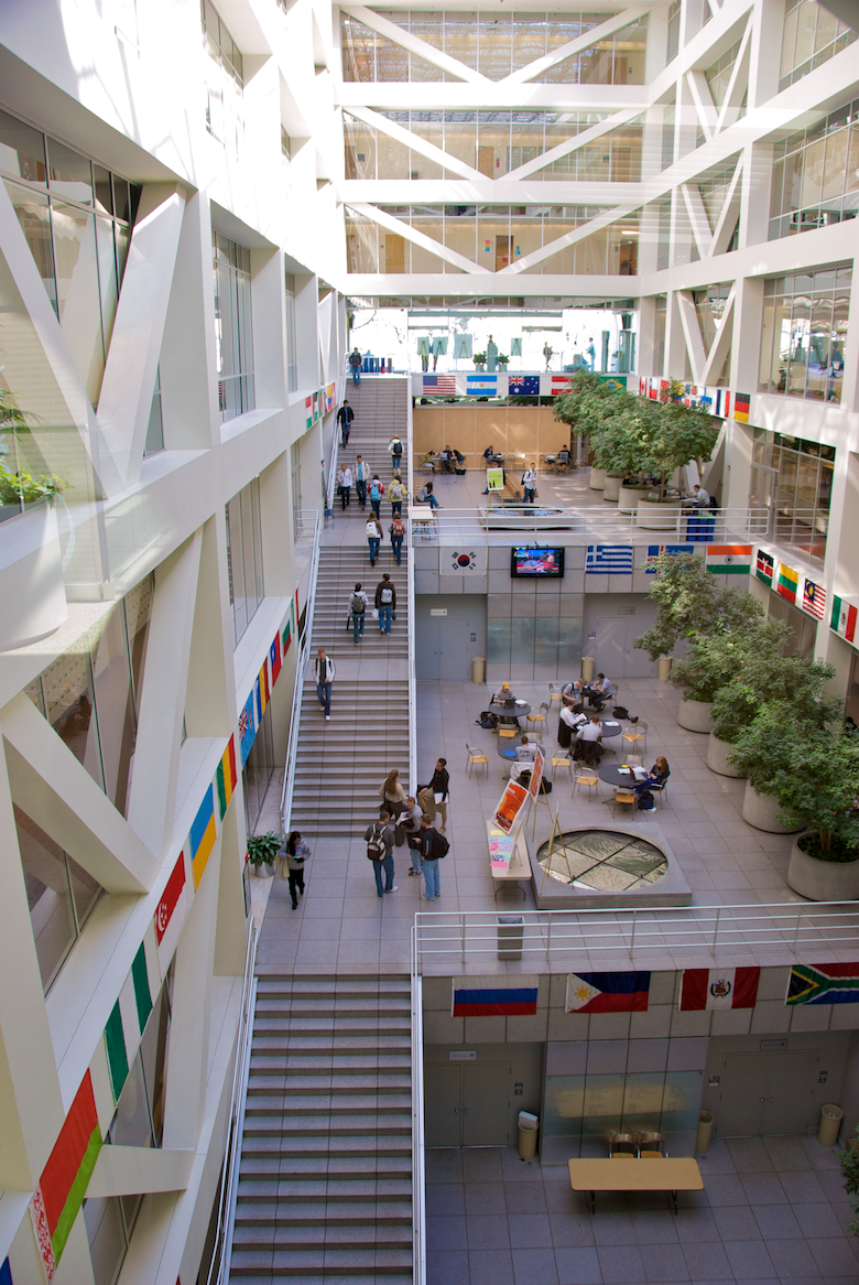 Large open building with granite steps running up the left side of the multi-storey building and modern fountains centered on each floor