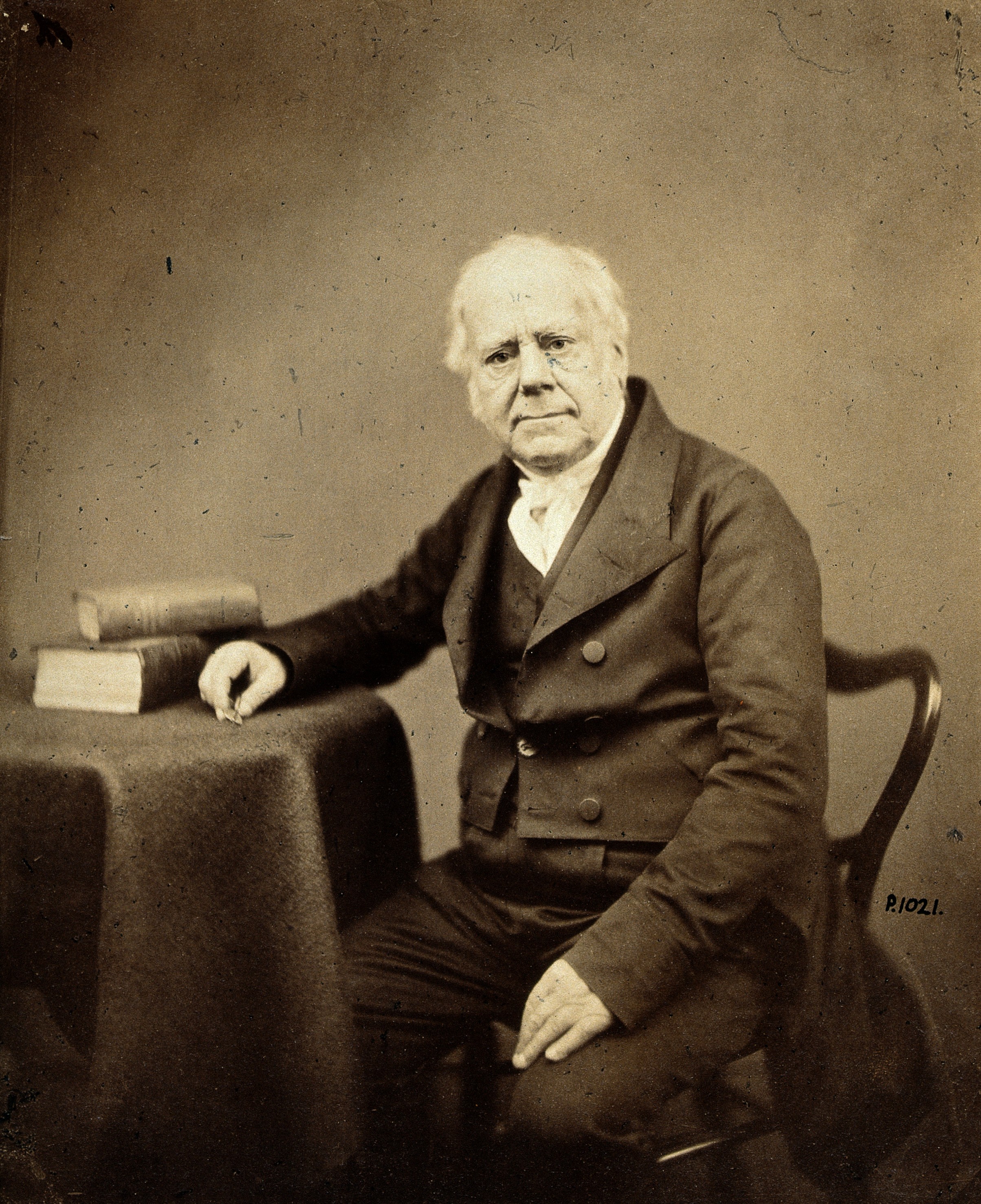 a middle-aged man in Victorian clothes, seated