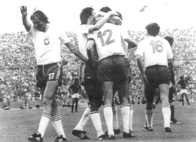 함께 축하하는 흰색 셔츠와 어두운 반바지를 입은 축구 선수들