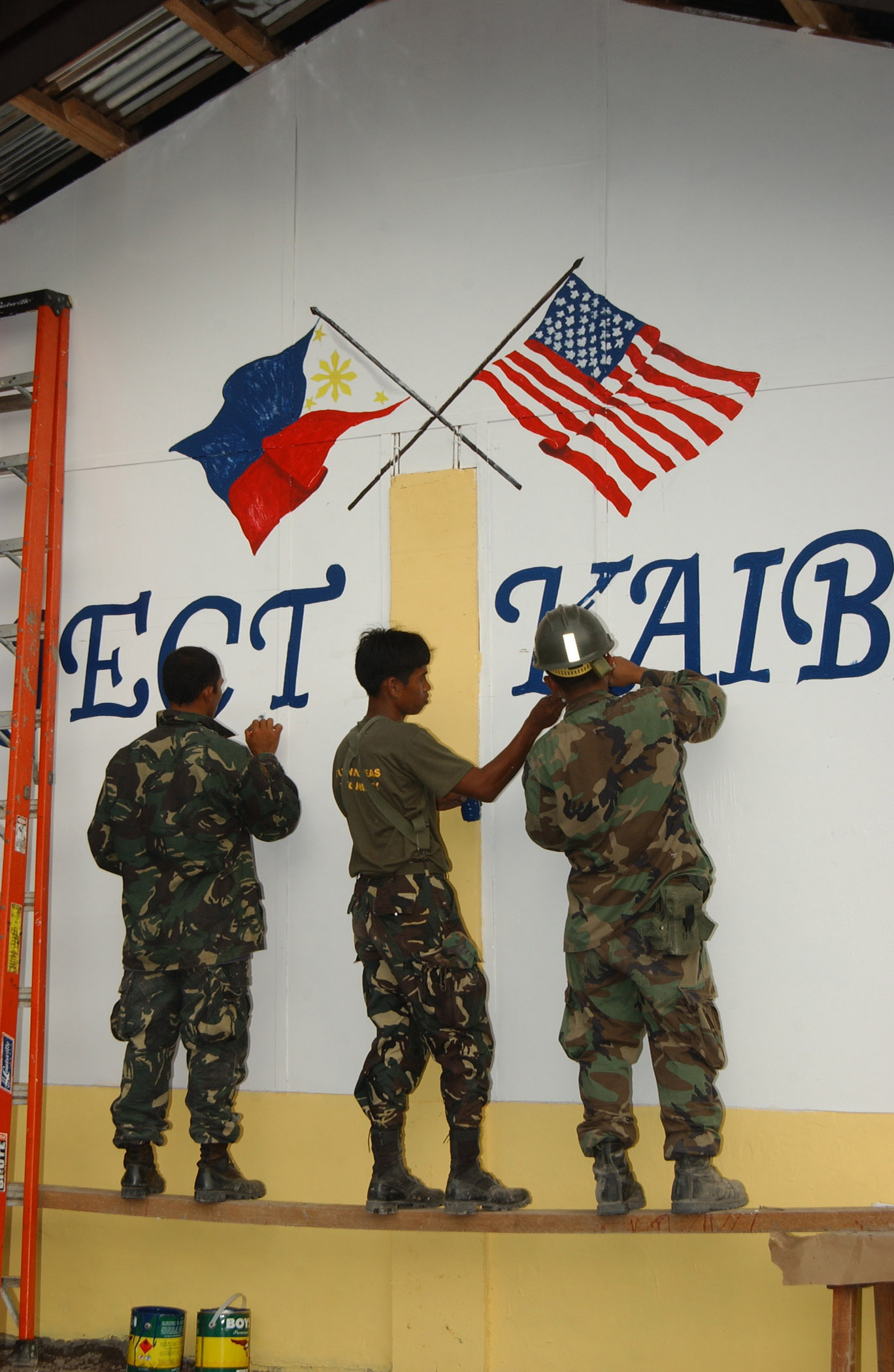 Filipino soldiers painting a U.S. and Philippine flag, symbolizing the close ties between the two nations.