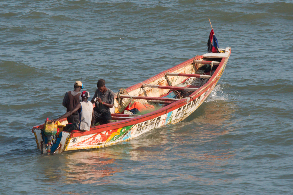 Brightly painted fishing boats are common in coastal areas like Bakau, indicative of the importance of the fisheries sector.